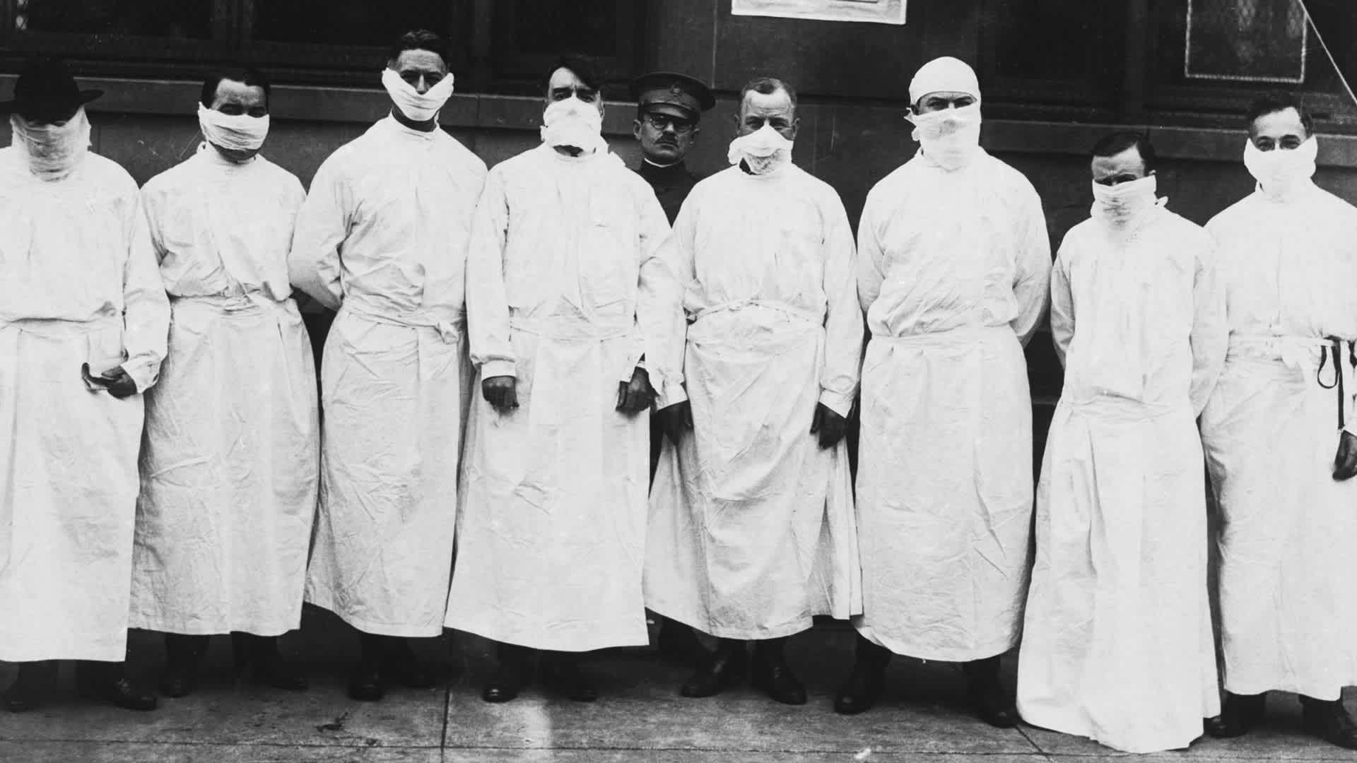 Doctors, army officers, and reporters wear surgical gowns and masks at a hospital to observe Spanish influenza treatment of patients
