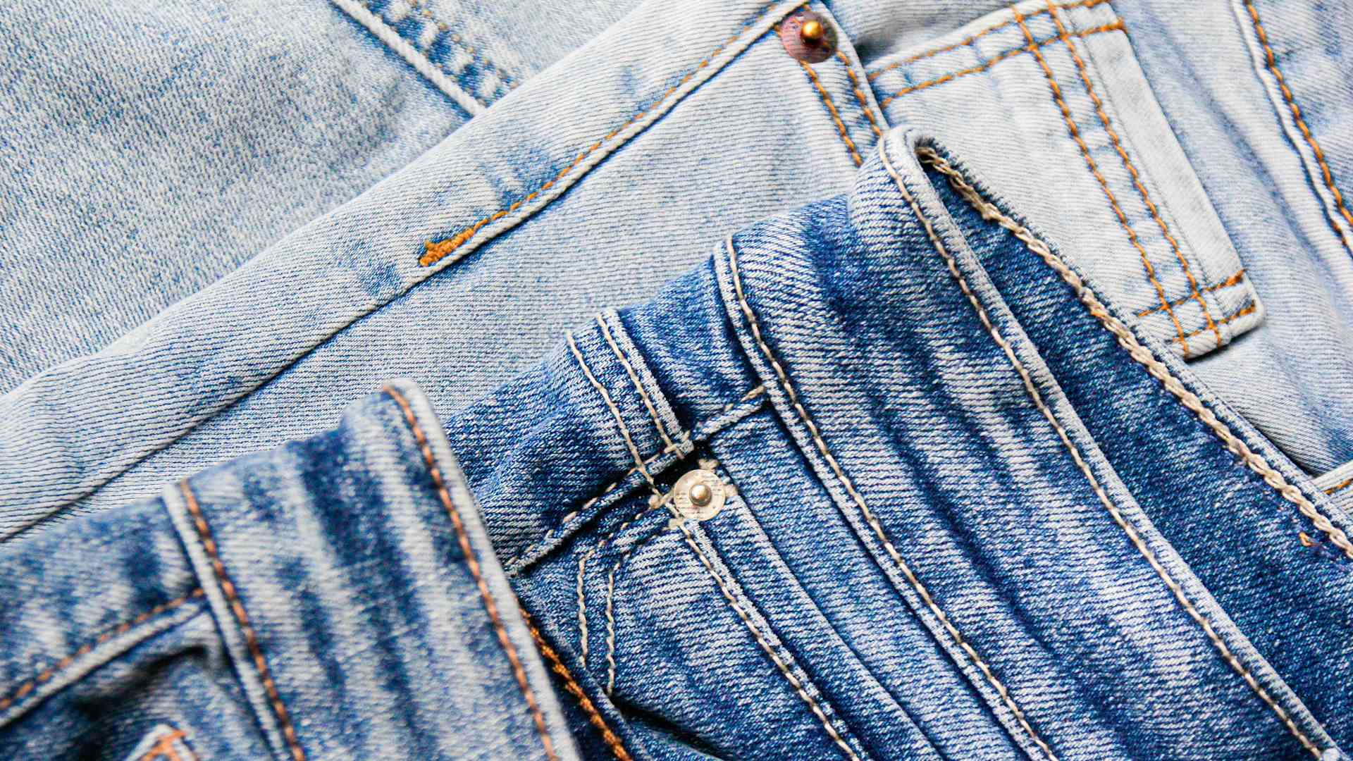 a pile of three pairs of folded jeans