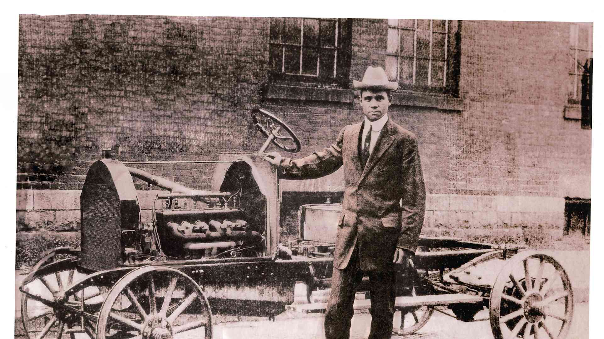 Frederick Patterson standing beside a bare Patterson-Greenfield automobile chassis, probably for a larger touring car body.