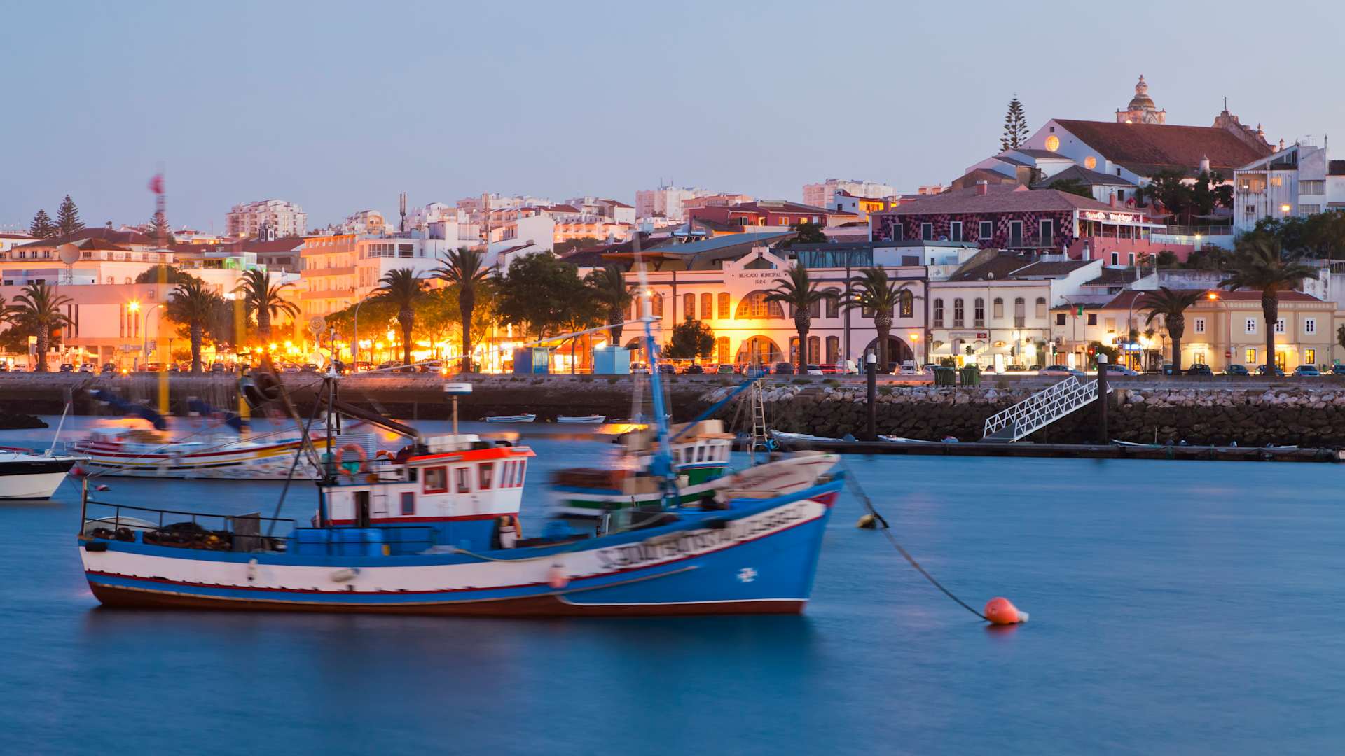 Portugal, Lagos, View of fishing boat at harbour and city in background