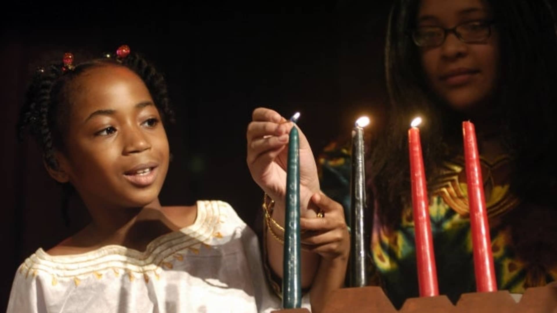 UNITED STATES - DECEMBER 29: Brooklyn students light a candle celebrating Ujamaa (Cooperative Economics), one of the Seven Principles of Kwanzaa, during a celebration at the American Museum of Natural History. The celebration kicks off the Museum's 2005 Kwanzaa festival, which will take place Dec. 29-31. (Photo by Linda Rosier/NY Daily News Archive via Getty Images)