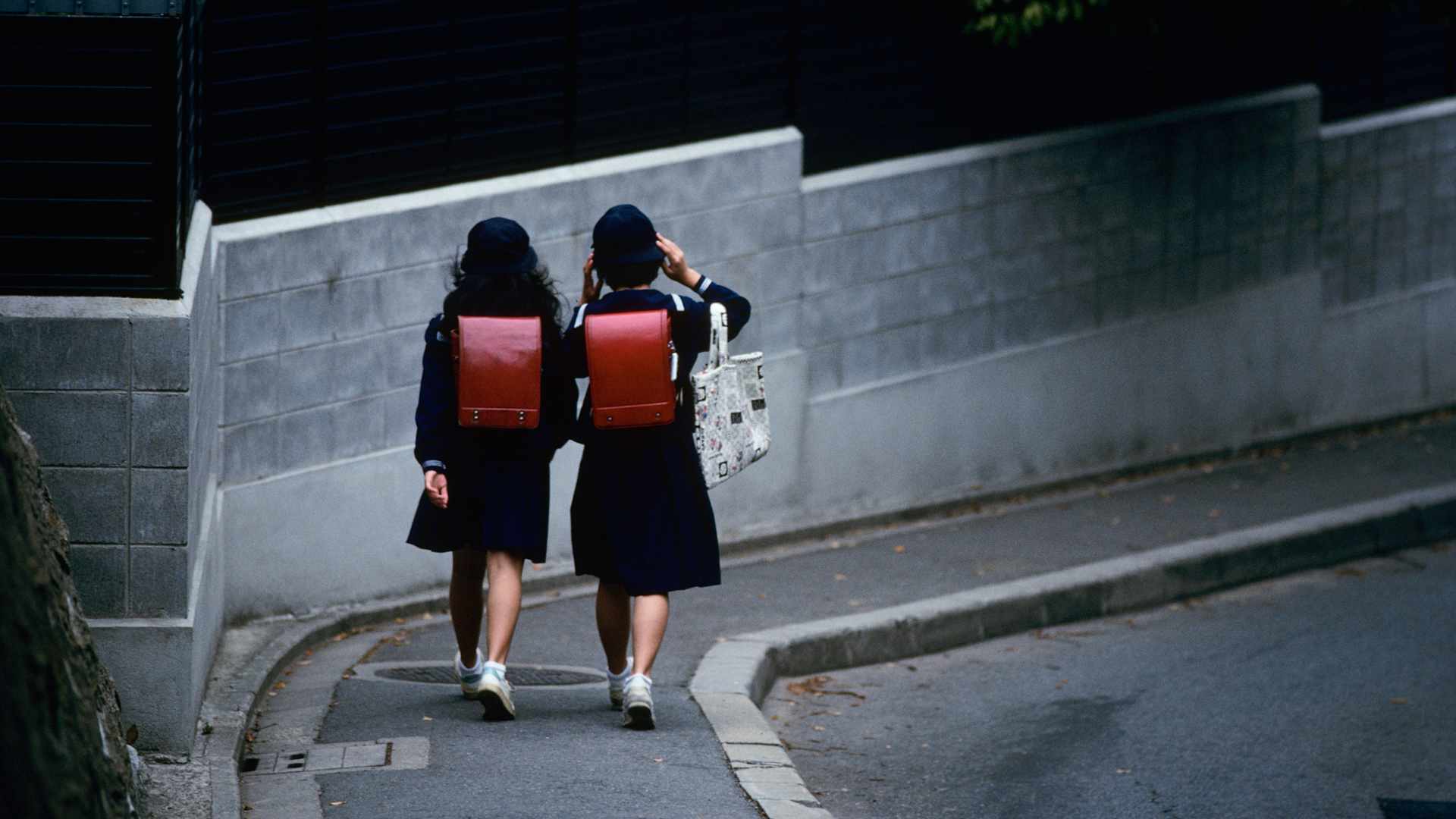 Schoolgirls Walking Along Sidewalk