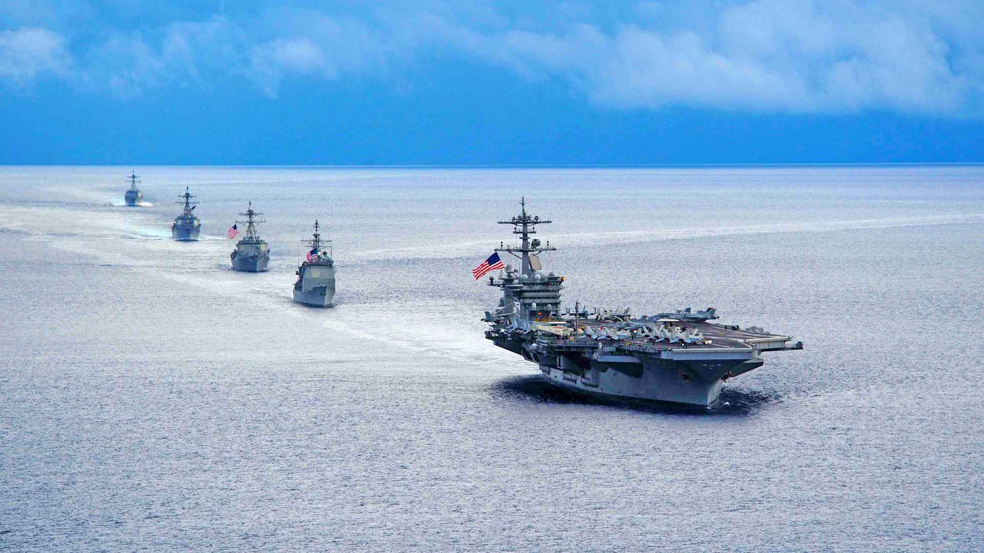The aircraft carrier USS Theodore Roosevelt leads a formation of ships from Carrier Strike Group 12 during a maneuvering exercise in the Atlantic Ocean, 2014.
