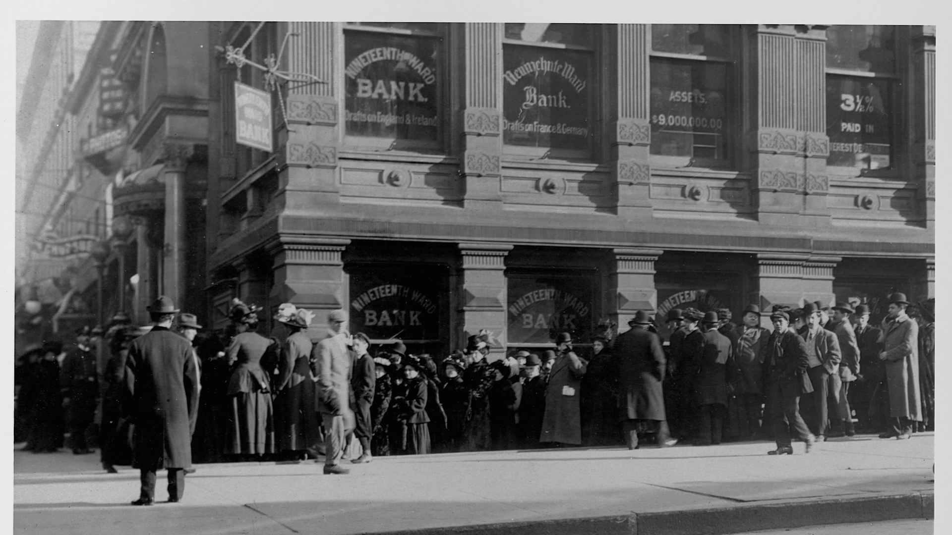 An anxious crowd gathers outside of New York's 19th Ward Bank, New York City.