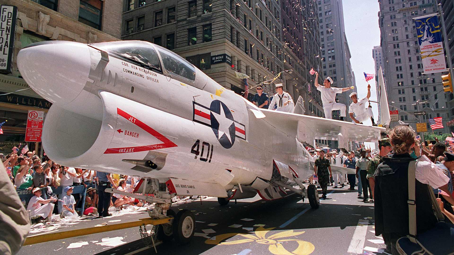 A Navy A-7 Corsair jet is pulled down Broadway in NYC as sailors rejoice on the wings during the Operation Welcome Home ticker tape  parade during the 10 June 1991 celebration for returning Gulf War troops.