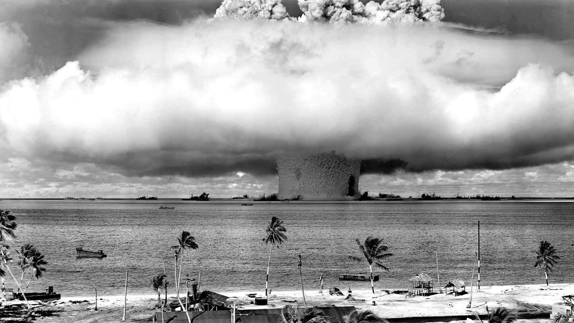 huge mushroom cloud exploding over a tropical island