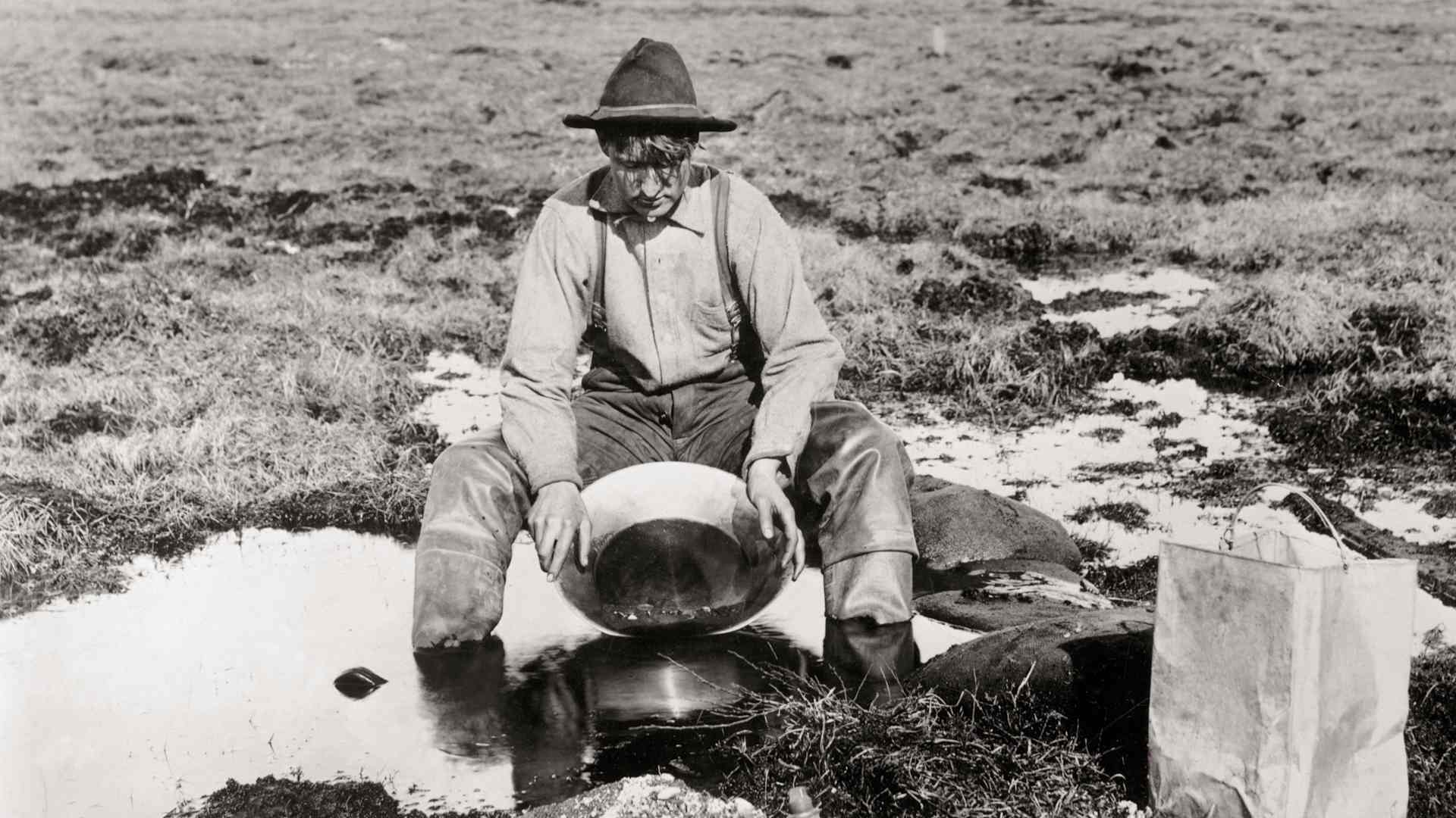 A man panning for gold in the Yukon during the Klondike Gold Rush.