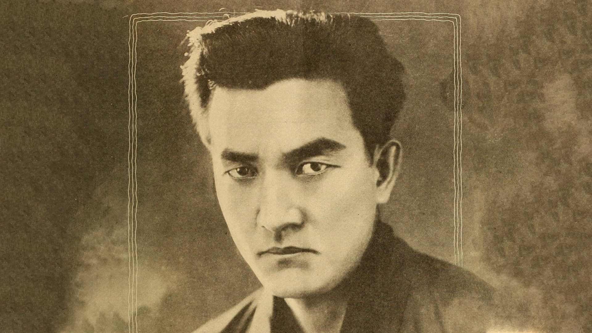 A black and white portrait of a serious-looking man with a strong jawline and intense gaze, set against a textured background.