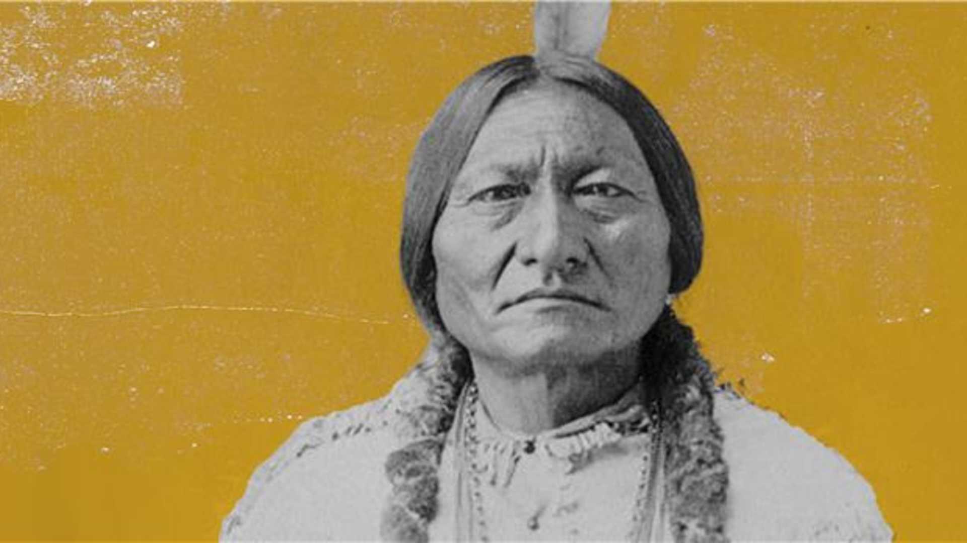 A black and white portrait of an elderly Native American man with a serious expression, set against a vibrant yellow background.