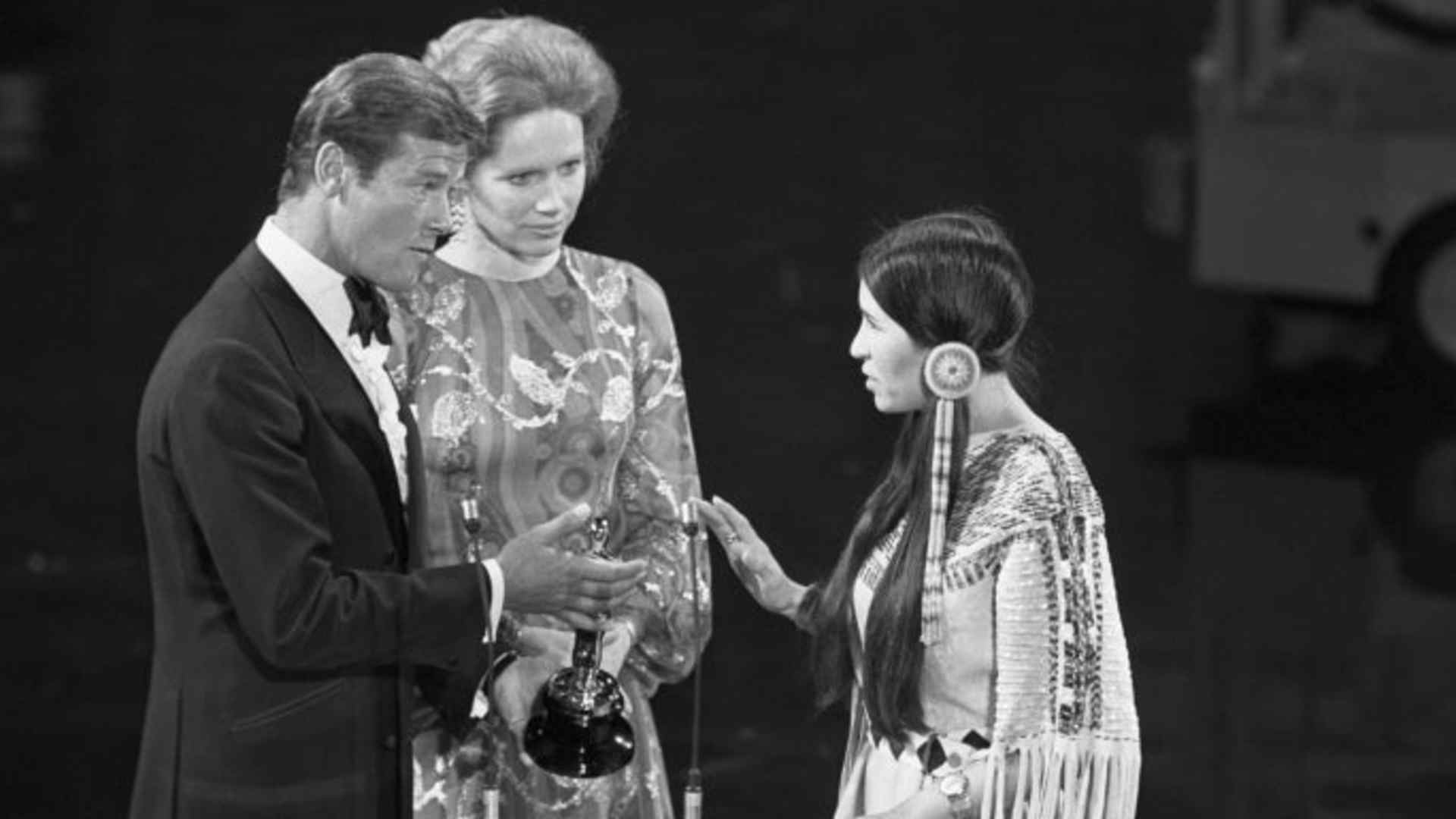 At the 1973 Academy Awards, Sacheen Littlefeather refuses the Academy Award for Best Actor on behalf of Marlon Brando who won for his role in The Godfather. She carries a letter from Brando in which he explains he refused the award in protest of American treatment of the Native Americans. (Credit: Bettmann Archive/Getty Images)
