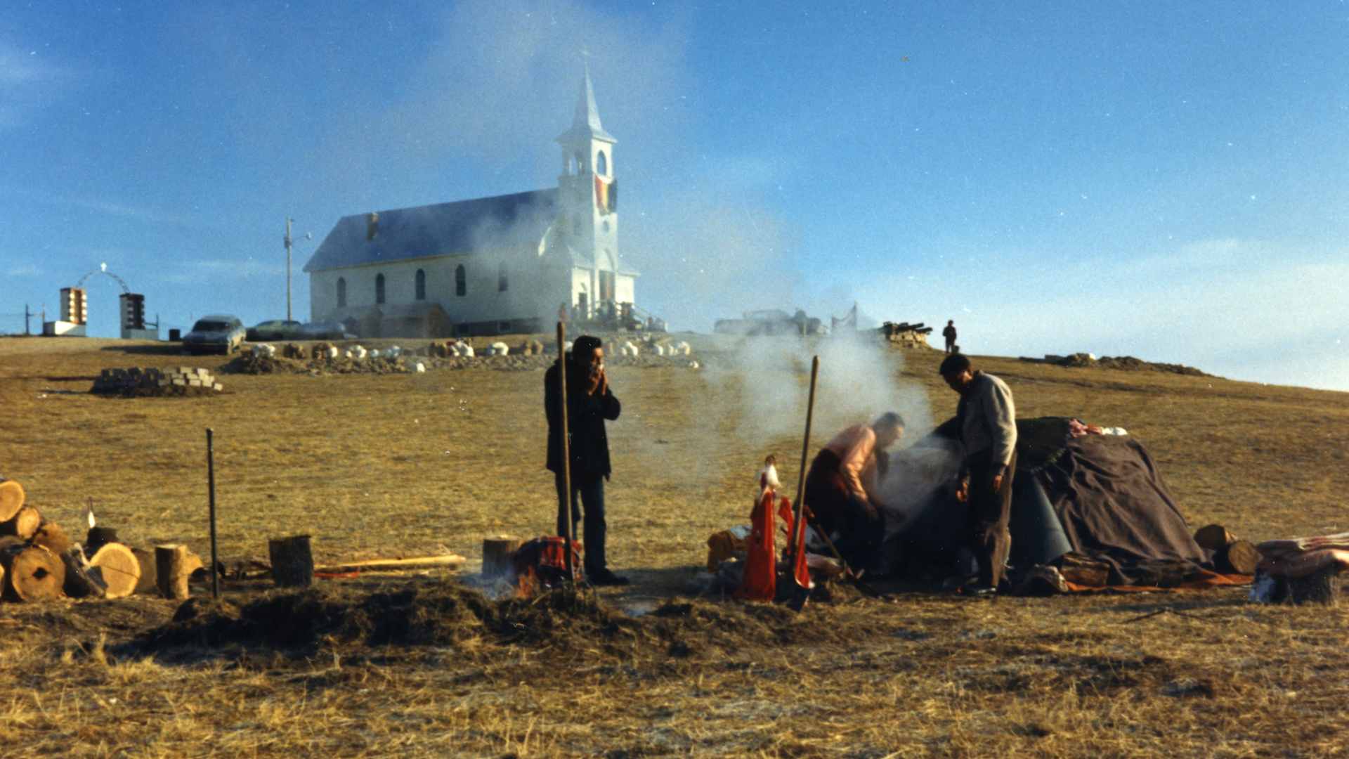 View of several members of the American Indian Movement (AIM) as they stand next to a sweat lodge erected on a hill below the Sacred Heart Church during the occupation of the town of Wounded Knee on the Pine Ridge Reservation, South Dakota, 1973. AIM occupied the town, exchanging gunfire with local and federal troops, from February 27 through May 8, 1973, following internal reservation disputes as well as disatisfaction with the US government's treatment of Native American peoples in general. (Photo by Peter Davis/Getty Images)