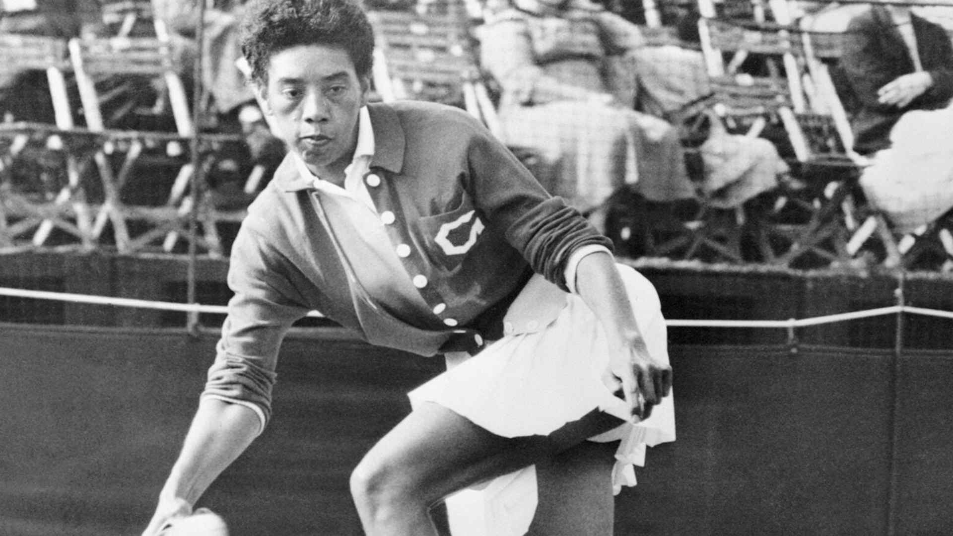 American tennis star Althea Gibson hits a return shot to Mlle. Monnot during her singles match at the Surrey Grass Court Championship, held at the Surbiton Racket and Fitness Club.