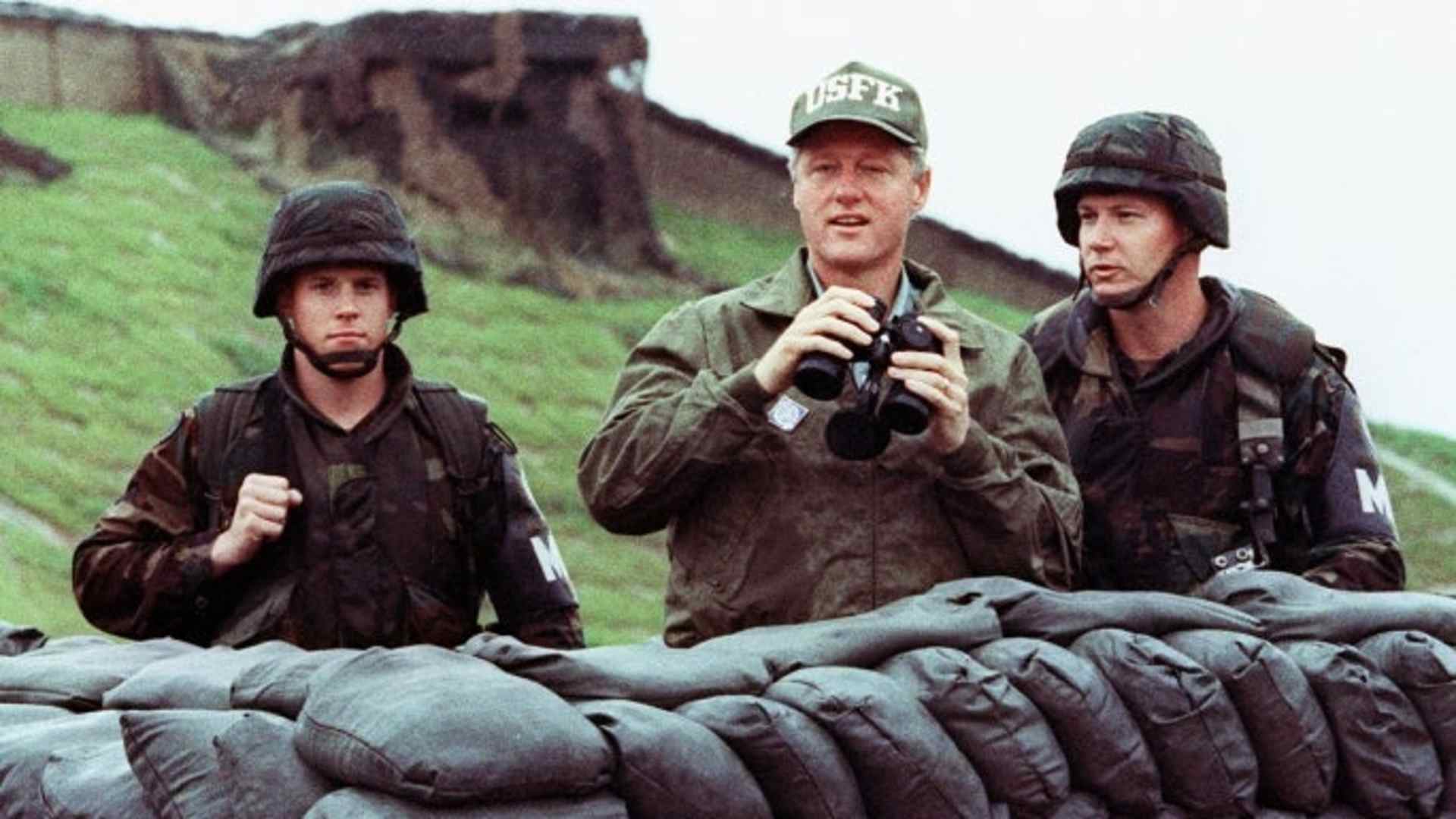 President Bill Clinton looking across the Demilitarized Zone into North Korea with two US soldiers during his trip to South Korea on July 11, 1993. (Credit: Luke Frazza/AFP/Getty Images)