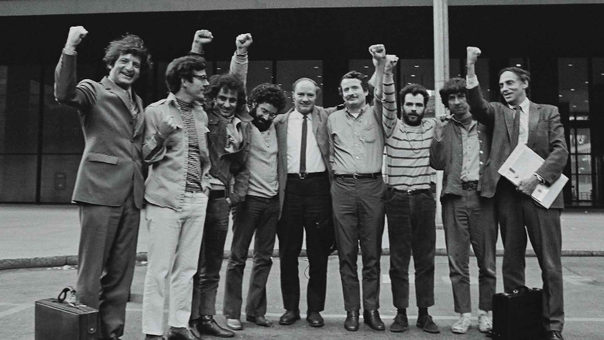 Portrait of the Chicago Seven and their lawyers as they raise their fists in unison outside the courthouse where they were on trial for conspiracy and inciting a riot during the 1968 Democratic National Convention, Chicago, Illinois, October 8, 1969.