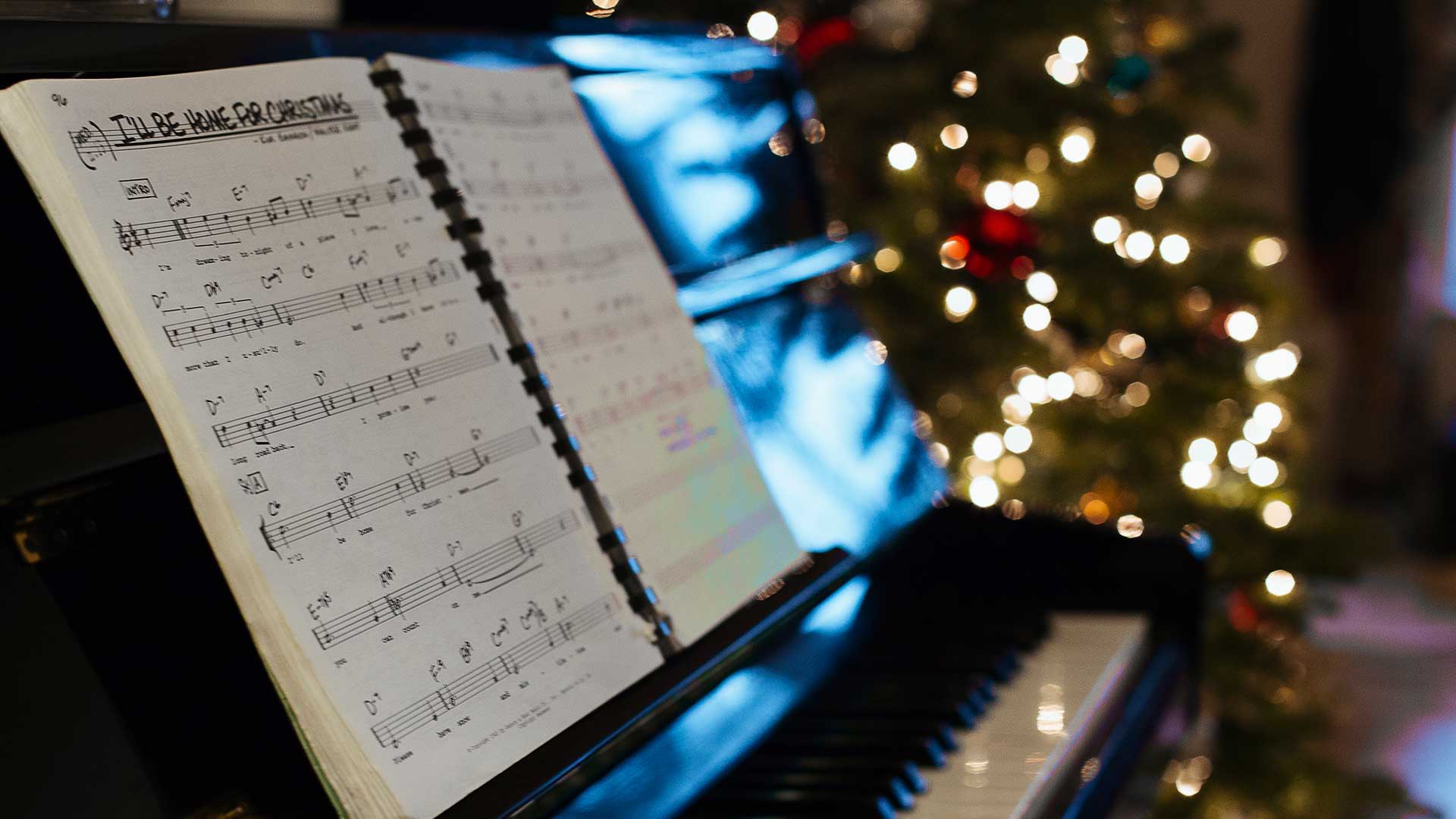 A Christmas songbook by a Christmas tree.