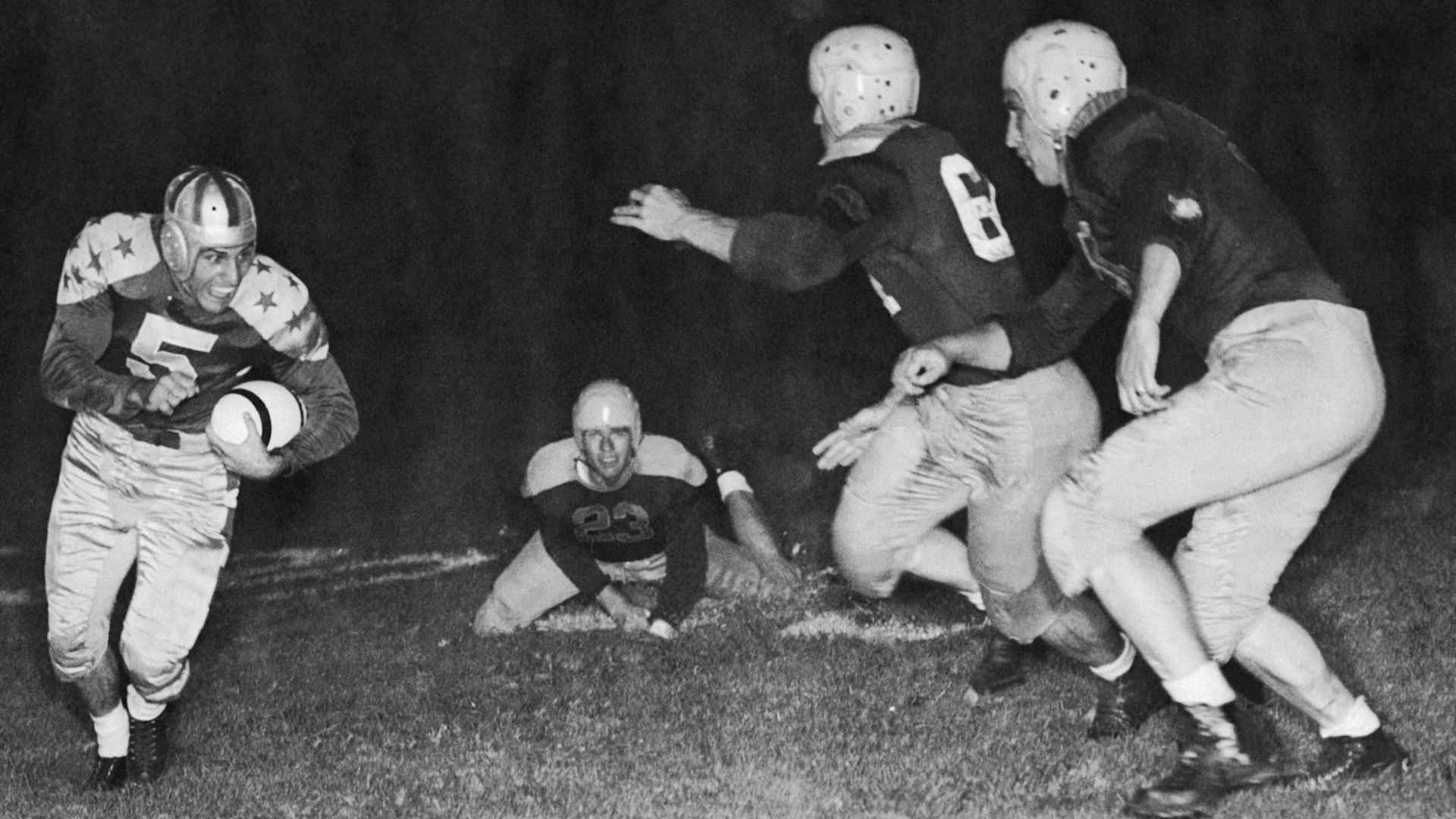 Charles Trippi (5), Georgia University, captain of the College All-Stars, lugs ball for wide sweep against Green Bay Packers, champions of the National Football League, in the 12th annual All-Star Game. Racing in for tackle are packers Clyde Goodnight (23), end; Ted Fritsch (64), half back; Don Perkins (53), full back. The Pro team defeated the All-Stars, 19-7, in Soldier's Field before 92,753 spectators.