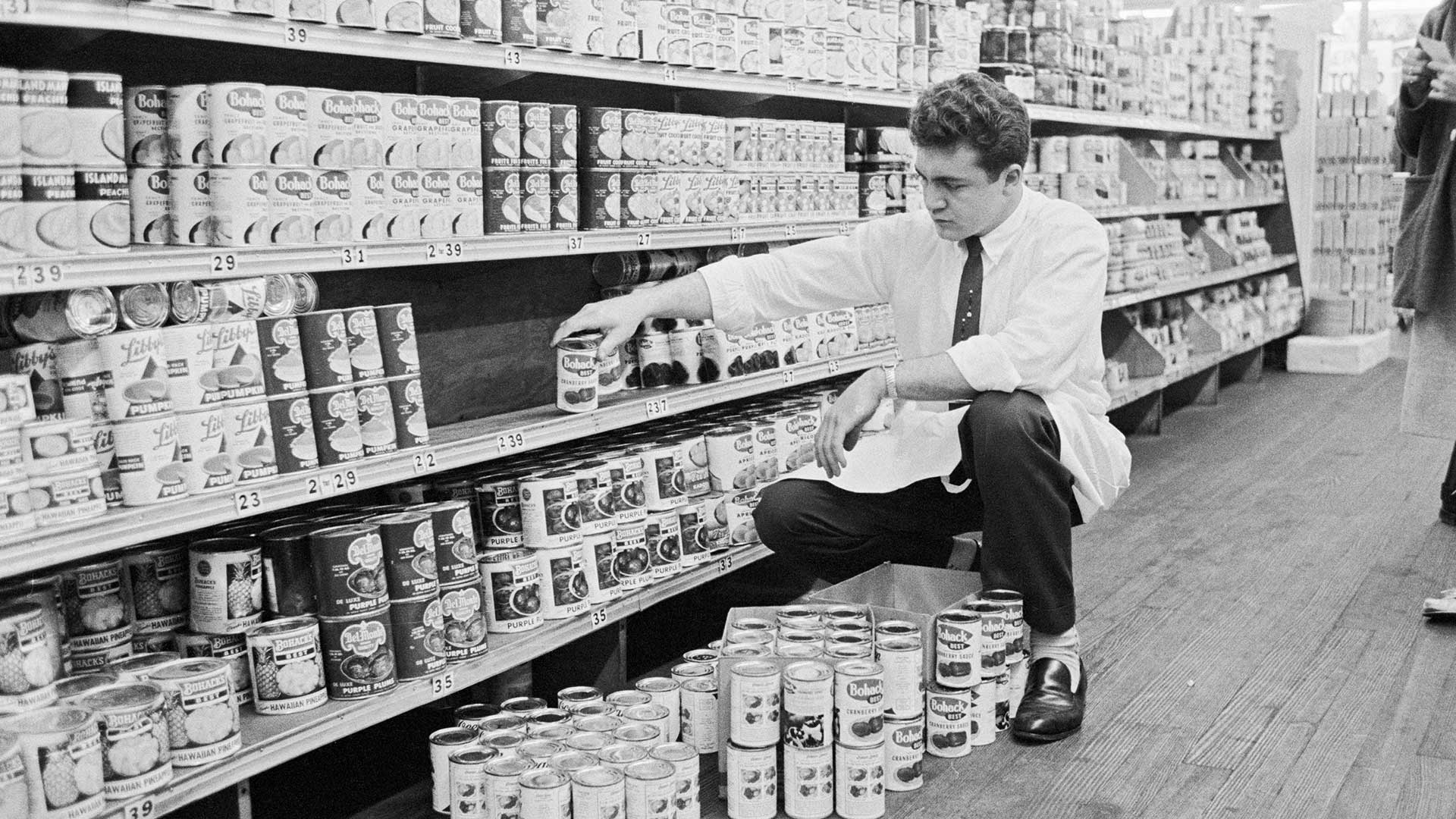 A clerk removes cans of cranberry from the shelves in a supermarket in Jackson Heights, Queens, Nov. 10, 1959.