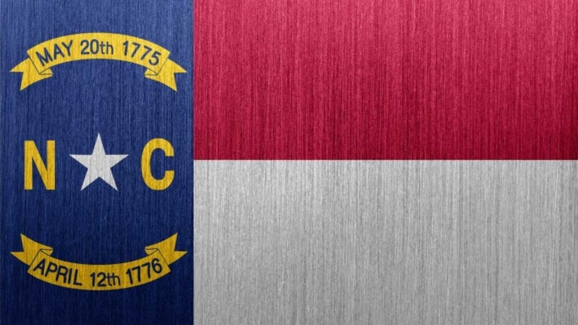 Flag of the US state of North Carolina on a brushed metal backgound