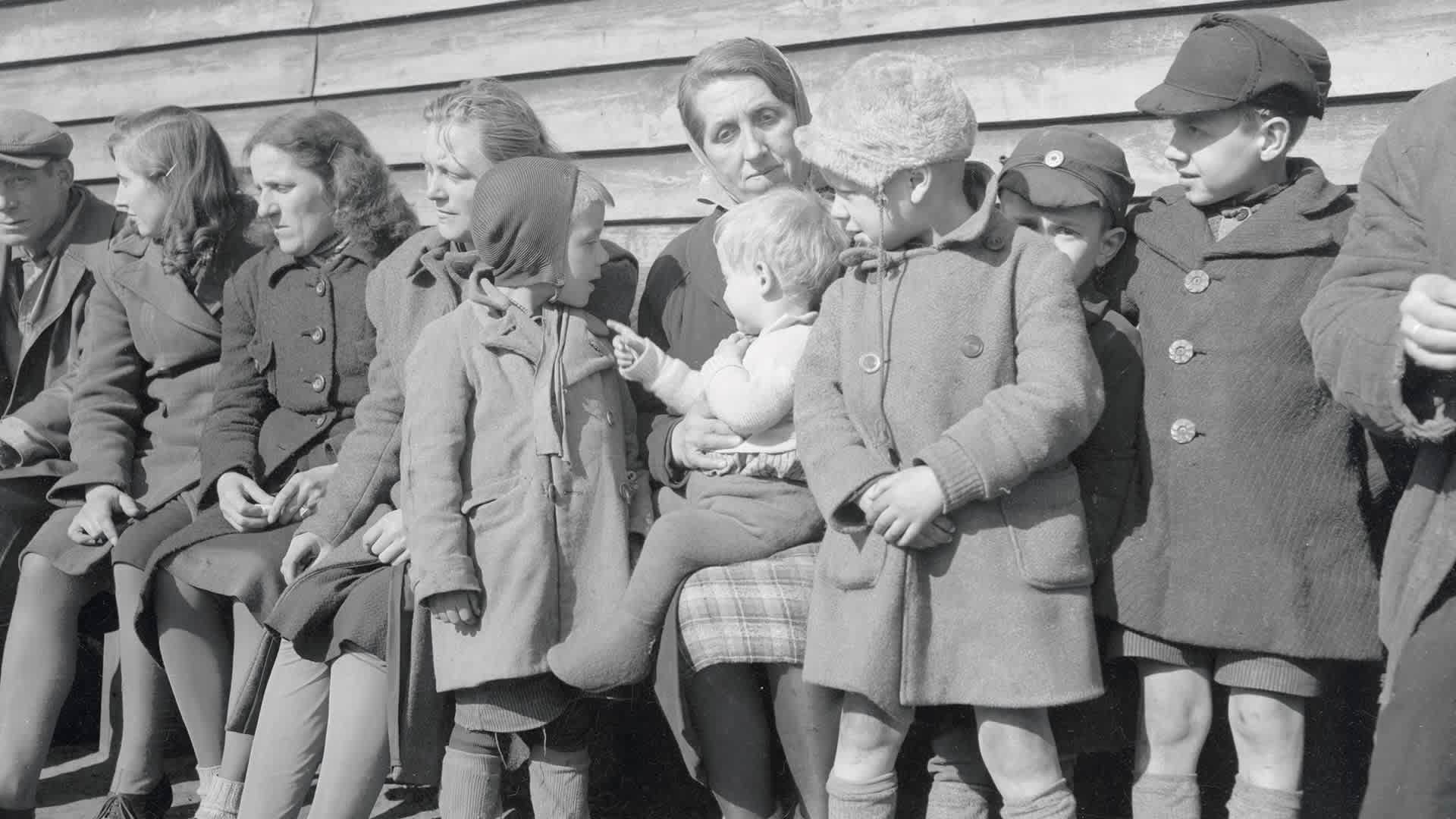 A mother sits with five of her children at a Displaced Persons Camp in Europe.