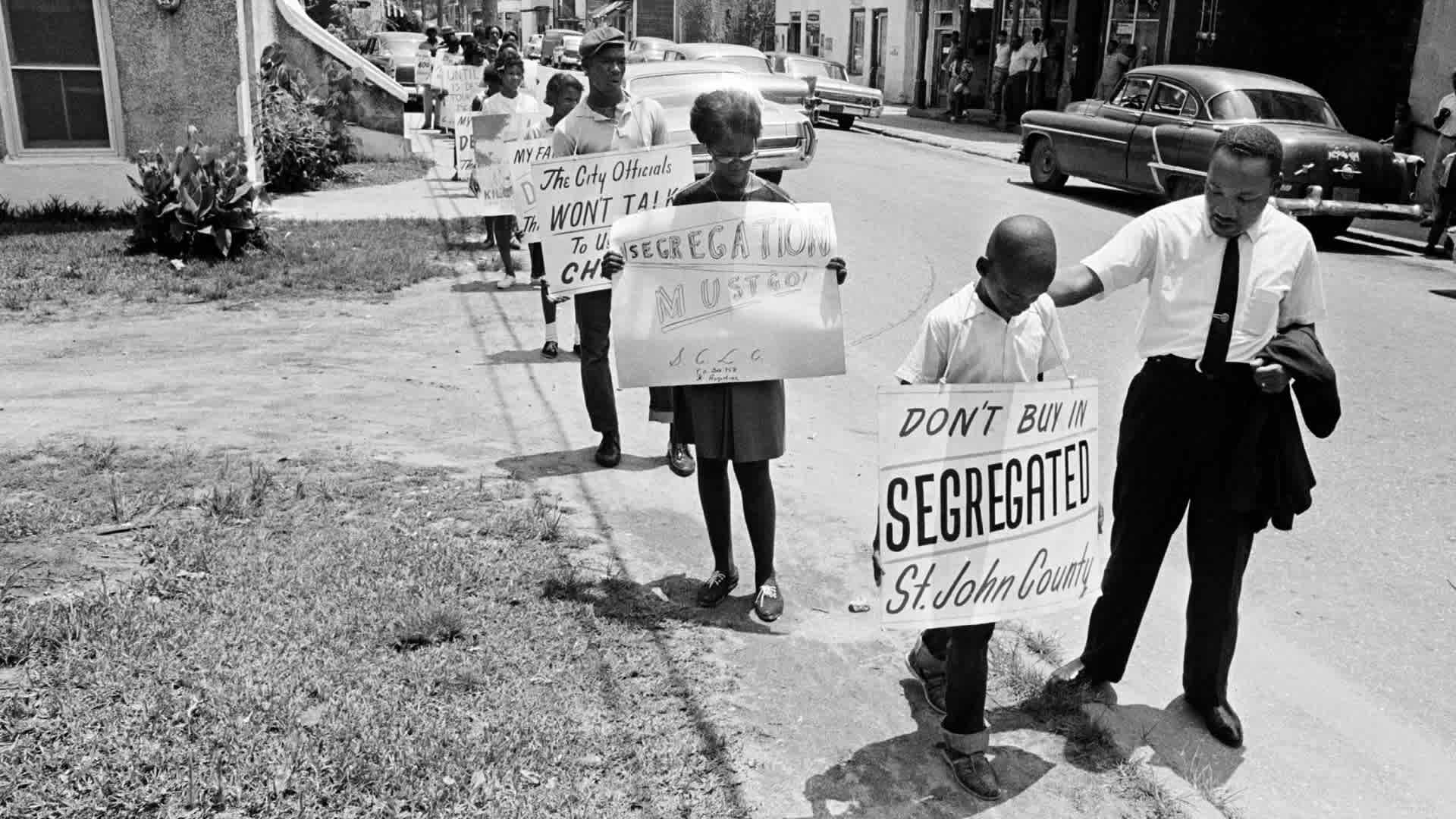 Dr. Martin Luther King, Jr. giving a young boy a pat on the back as a group of young people started to picket in St. Augustine, Florida, June 10, 1964. (Credit: AP Photo)