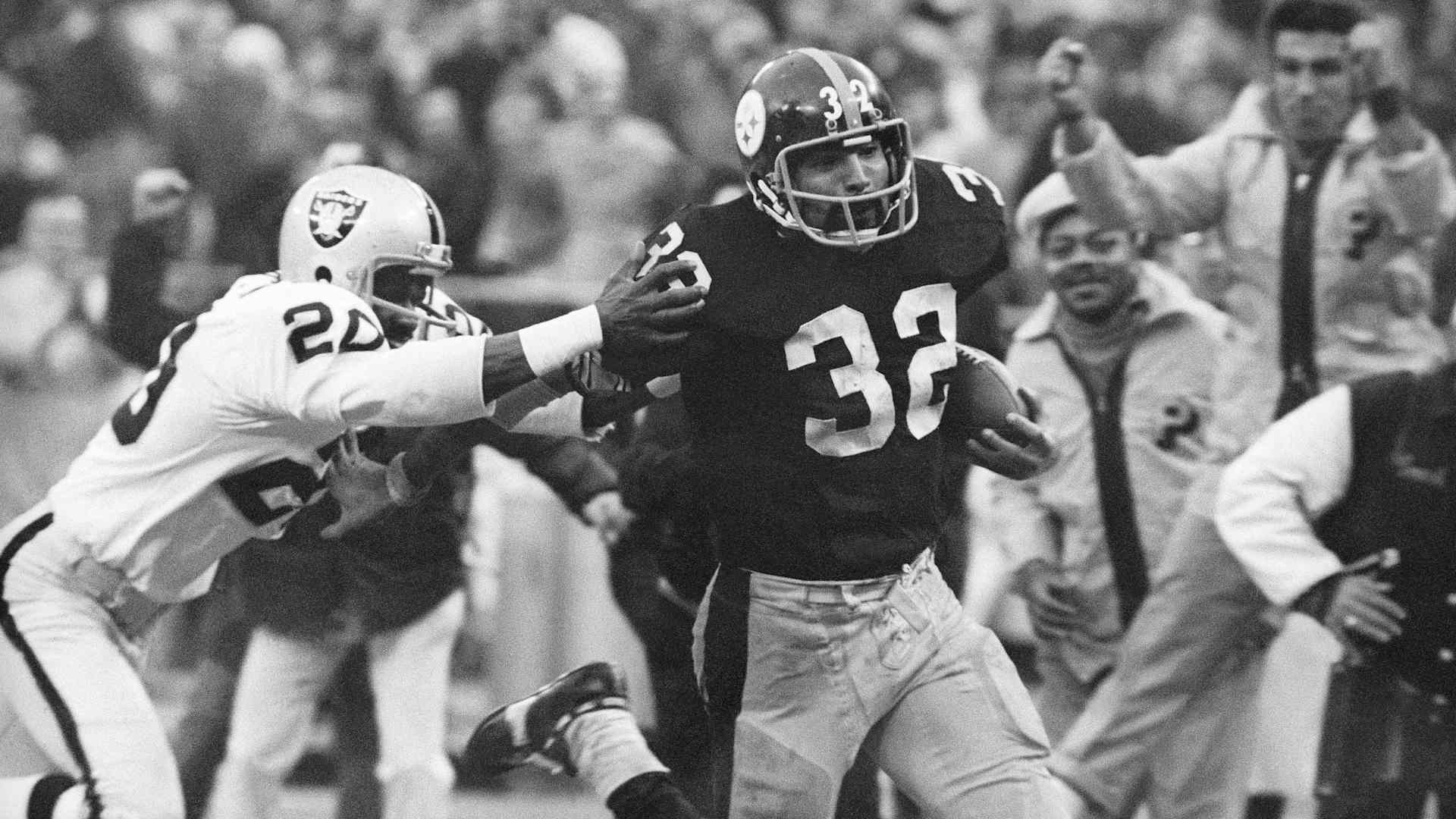 In this Dec. 23, 1972, file photo, Pittsburgh Steelers' Franco Harris (32) eludes a tackle by Oakland Raiders' Jimmy Warren as he runs 42-yards for a touchdown after catching a deflected pass during an AFC Divisional NFL football playoff game in Pittsburgh. Harris' scoop of a deflected pass and subsequent run for the winning touchdown, forever known as the "Immaculate Reception." (AP Photo/Harry Cabluck, File)