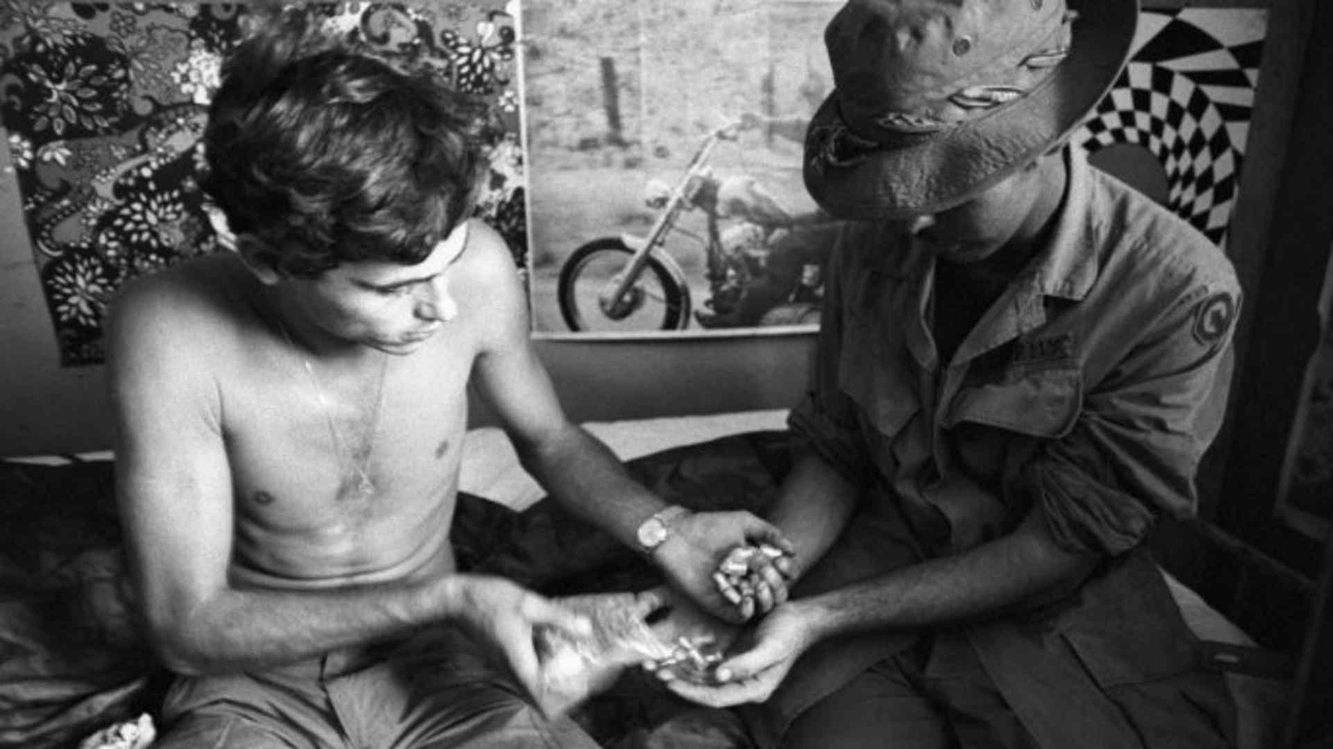 Two U.S. soldiers in Vietnam exchanging vials of heroin. (Credit: Bettmann Archive/Getty Images)