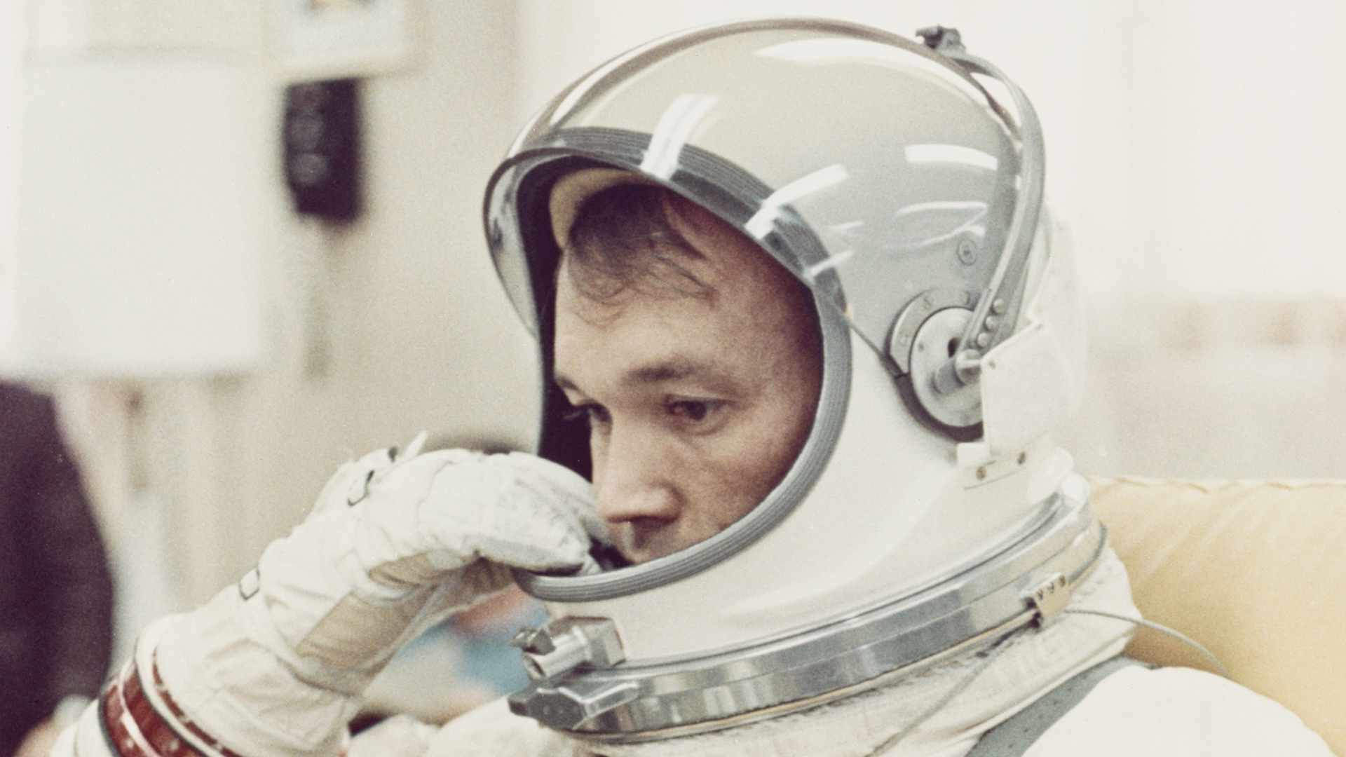 Pilot Michael Collins adjusts the helmet of his space suit in the Ready Room at Cape Kennedy in Florida, before NASA's Gemini 10 mission, July 1966. (Photo by Space Frontiers/Getty Images)