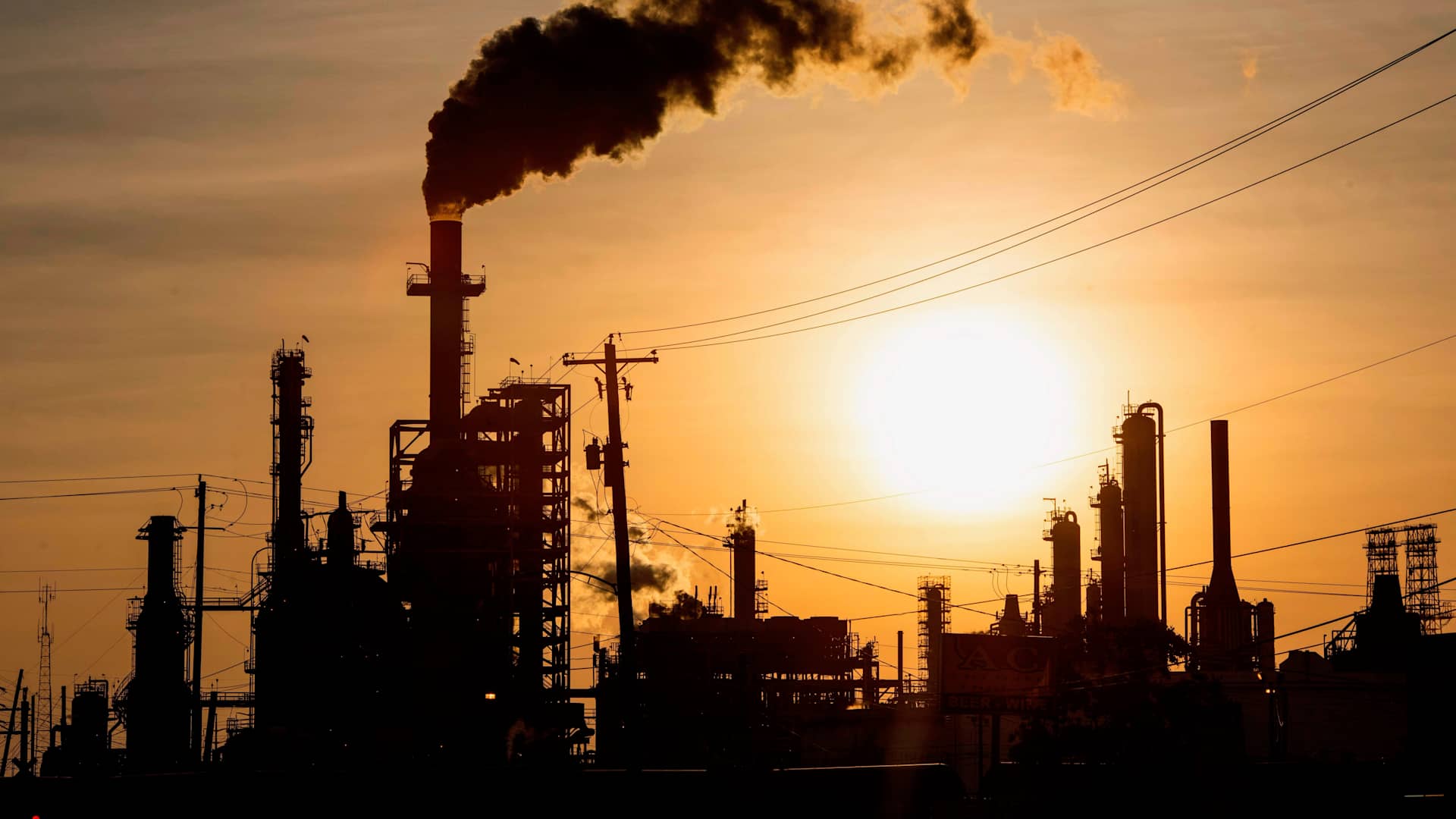 TOPSHOT - The sun sets behind smoke rising from the LyondellBasell-Houston Refining plant in Houston, Texas, on April 20, 2020. - US oil prices crashed to unprecedented lows on April 20 as futures in New York ended in negative territory for the first time amid a devastating supply glut that has forced traders to pay others to take the crude off their hands. (Photo by Mark Felix / AFP) (Photo by MARK FELIX/AFP /AFP via Getty Images)