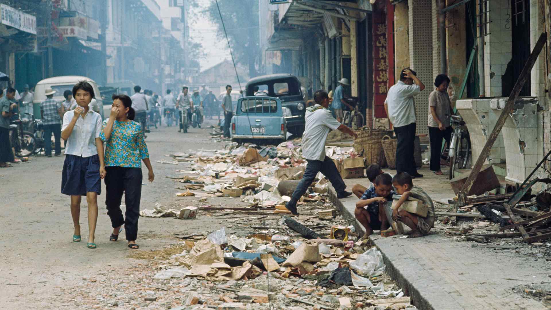 Pedestrians on the streets which are strewn with debris following heavy fighting during part of the Tet Offensive operations of the Vietnam War, in the Cholon district of Saigon (now Ho Chi Minh City).