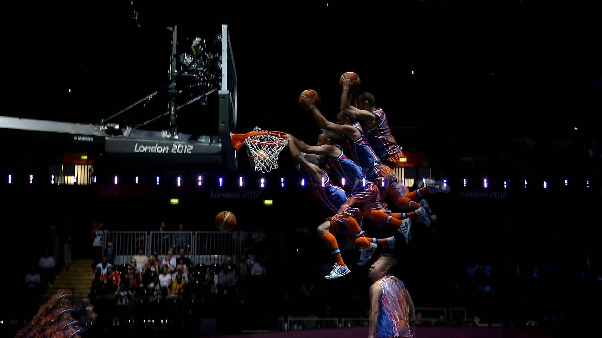 A performer dunks a ball as he performs during halftime during the Men's Basketball Preliminary Round match between France and Nigeria at the 2012 Olympic Games.