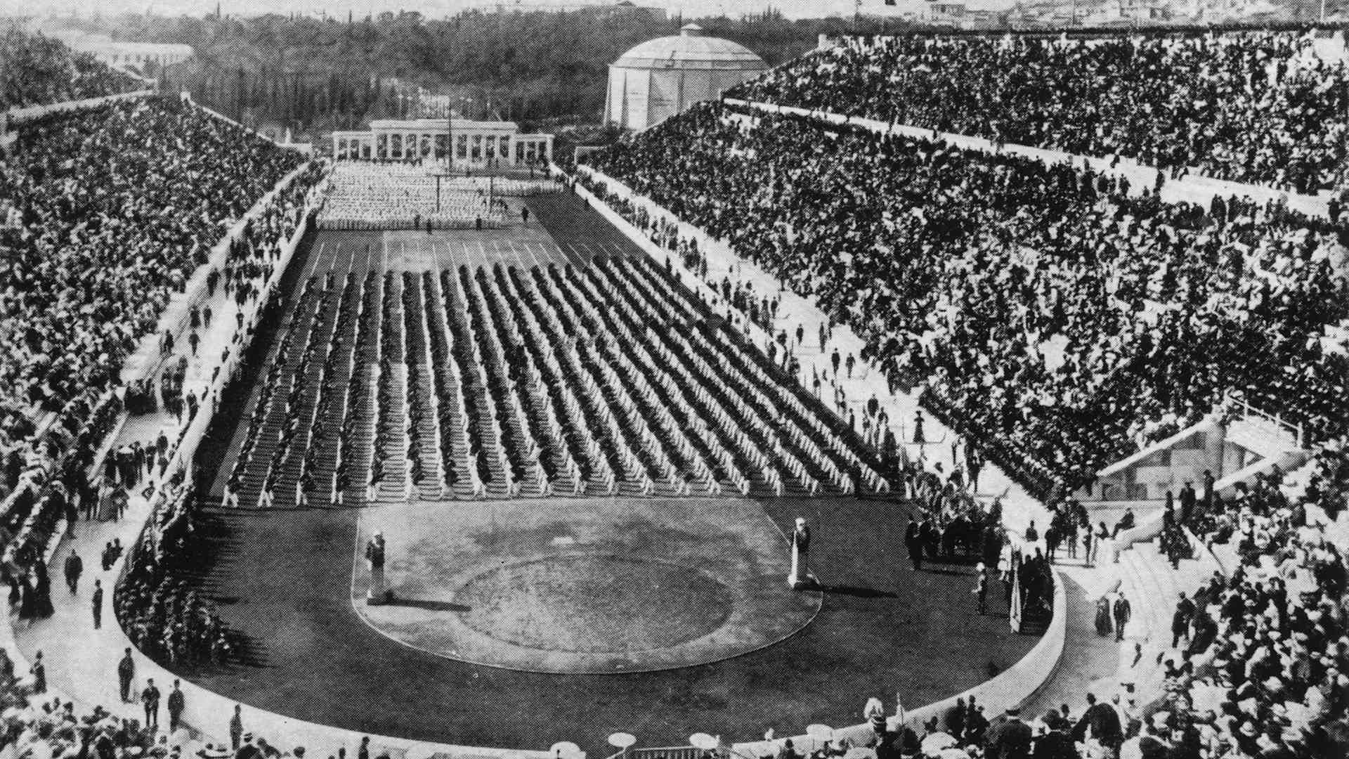 1896: View of athletes, standing in rows, and crowds filling the stadium at the 1896 Olympic Games in Athens, Greece.