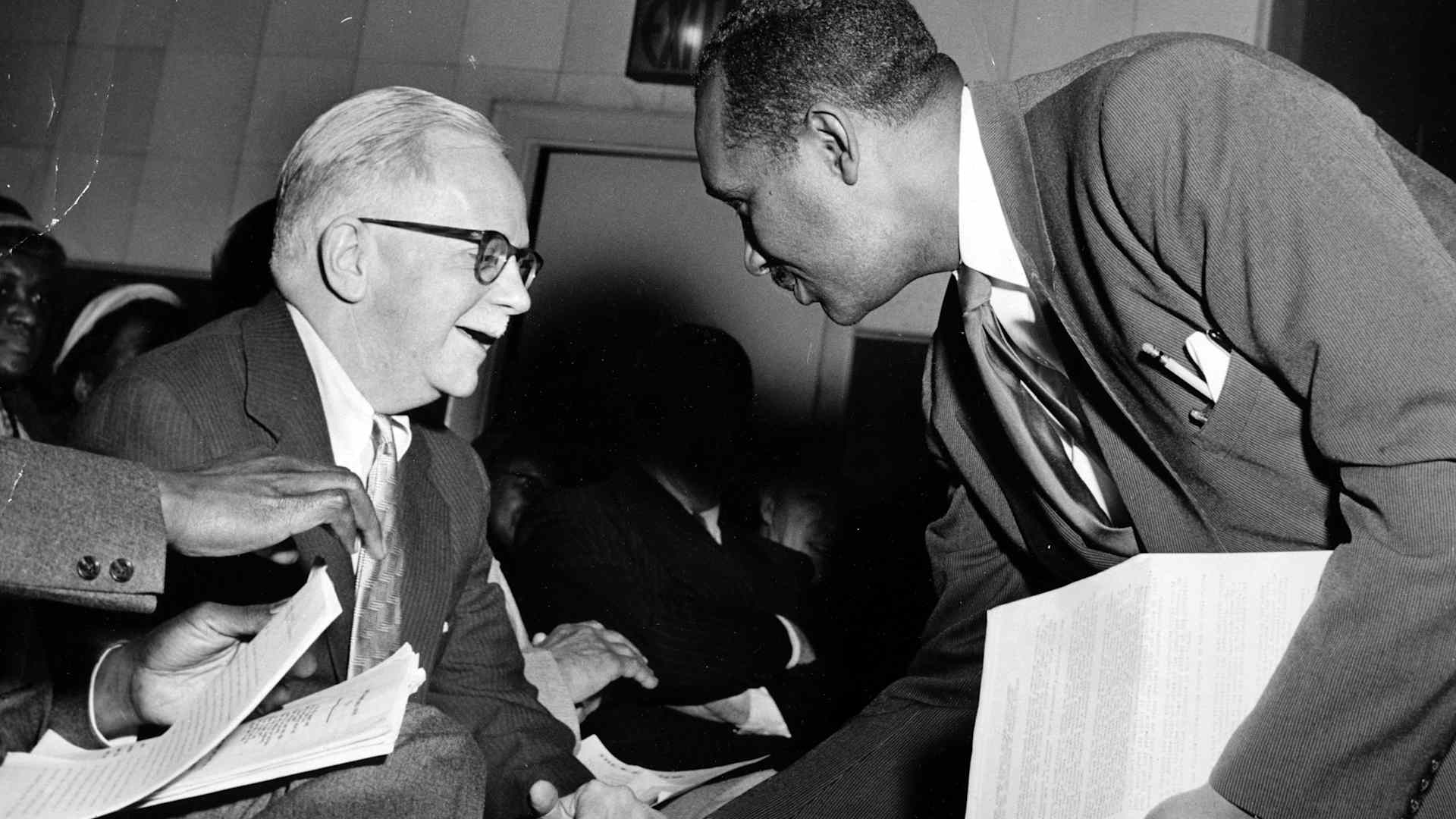 NAACP Secretary Walter White shakes hands with an African American man, 1950
