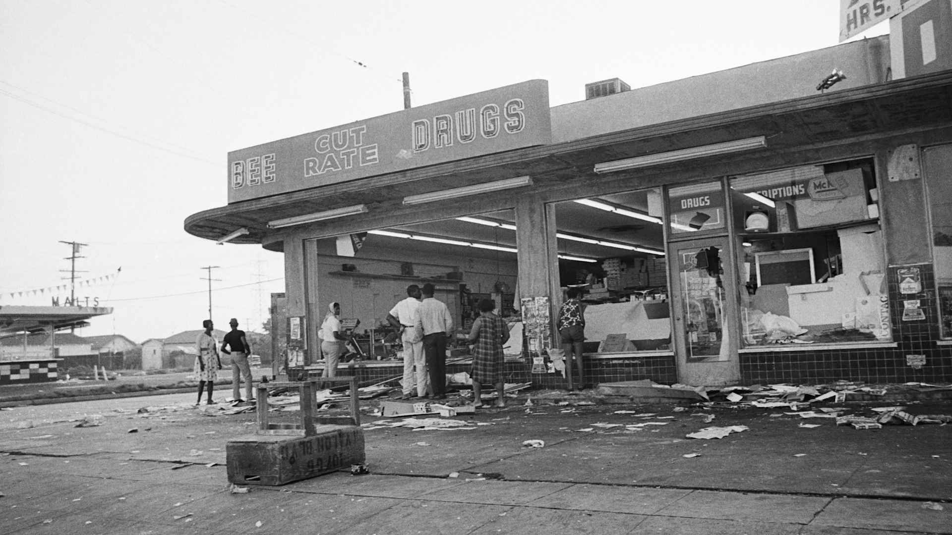 Residents look over damage following the second night of the Watts Rebellion in Los Angeles.