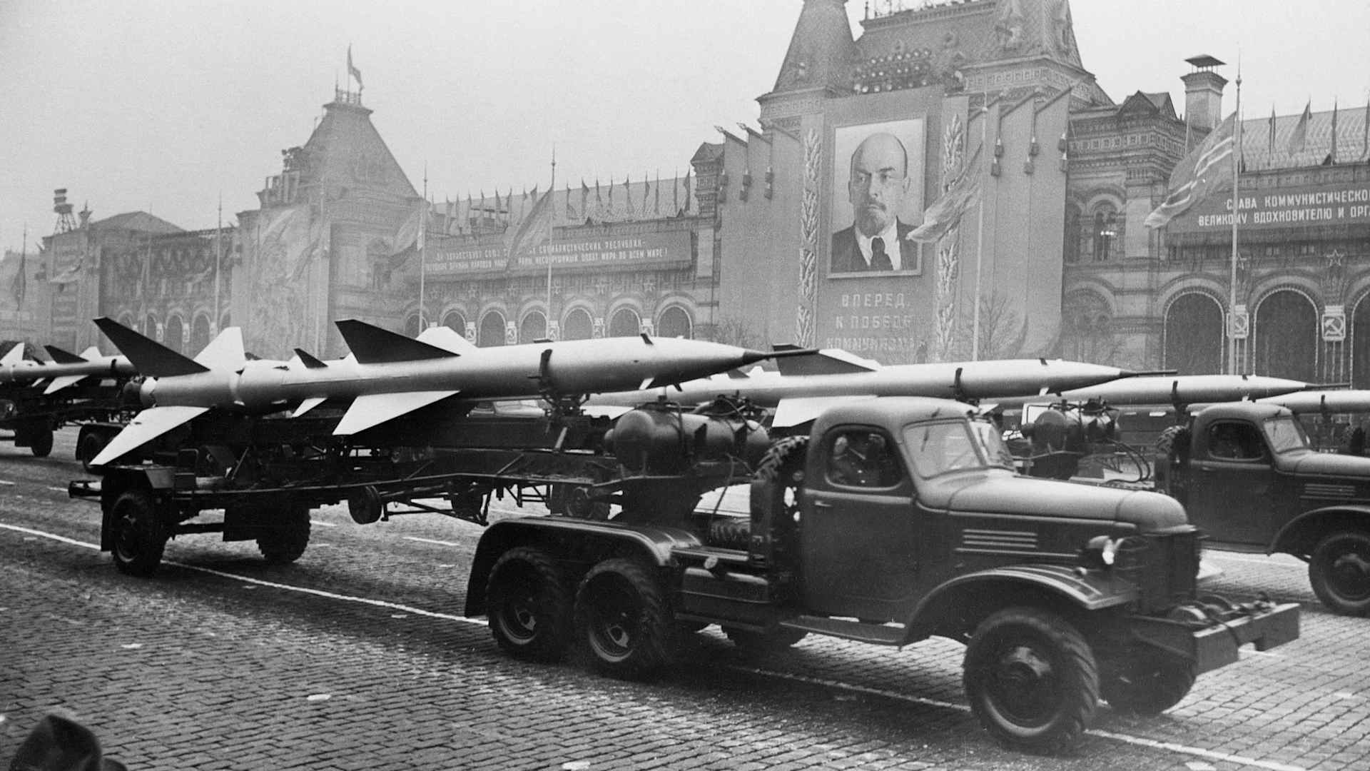 Military trucks pull trailers of short-range, two-stage missiles with twin tail assembly past the Kremlin. The Soviet Union unveiled a wealth of secret rocket weapons as the highlight of a massive armed display in the Red Square, commemorating the 40th anniversary of the Bolshevik Revolution.