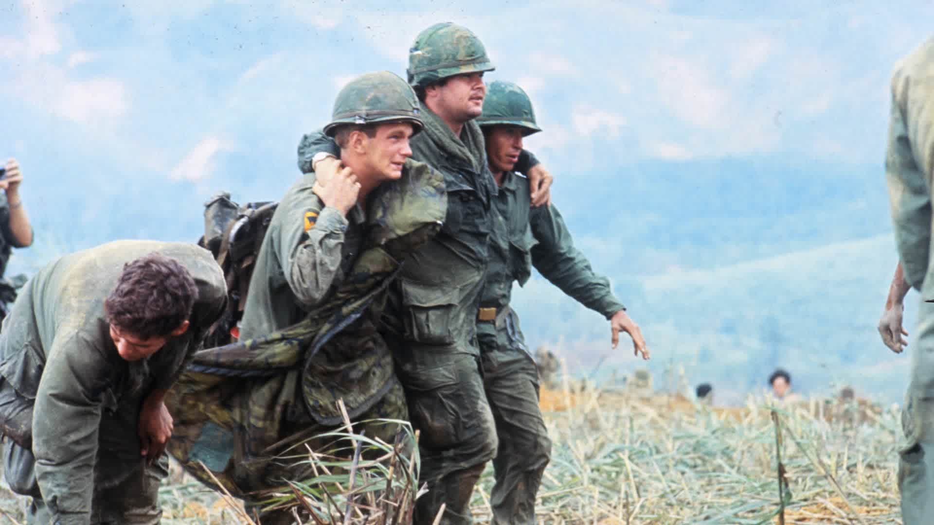 Two First Cavalry men support a wounded third as they advance along Route #9 en route to Khe Sanh.