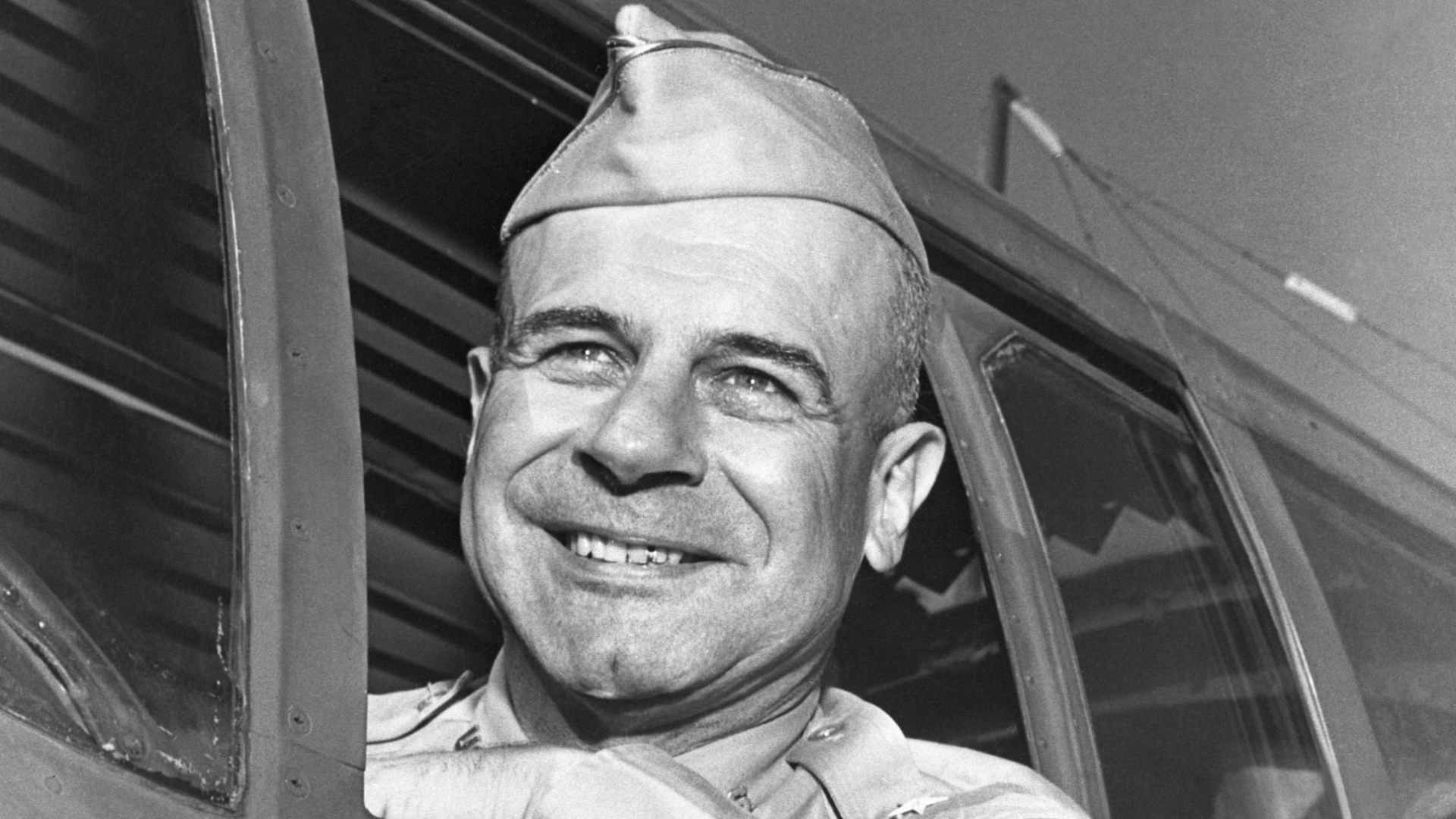 Brigadier General James H. Doolittle leans out the window of his bomber plane and smiles. Undated photograph c 1943.