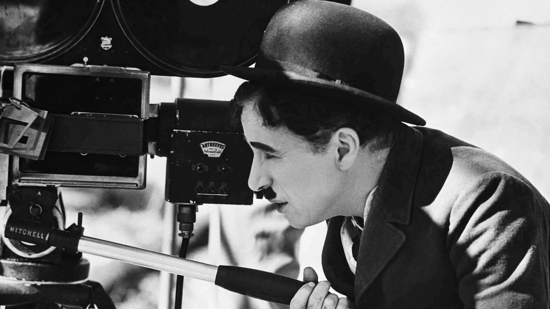 Actor Charlie Chaplin looks though a movie camera on April 22, 1935. He is directing, as well as acting in, a comedy tentatively titled Production No. 5.