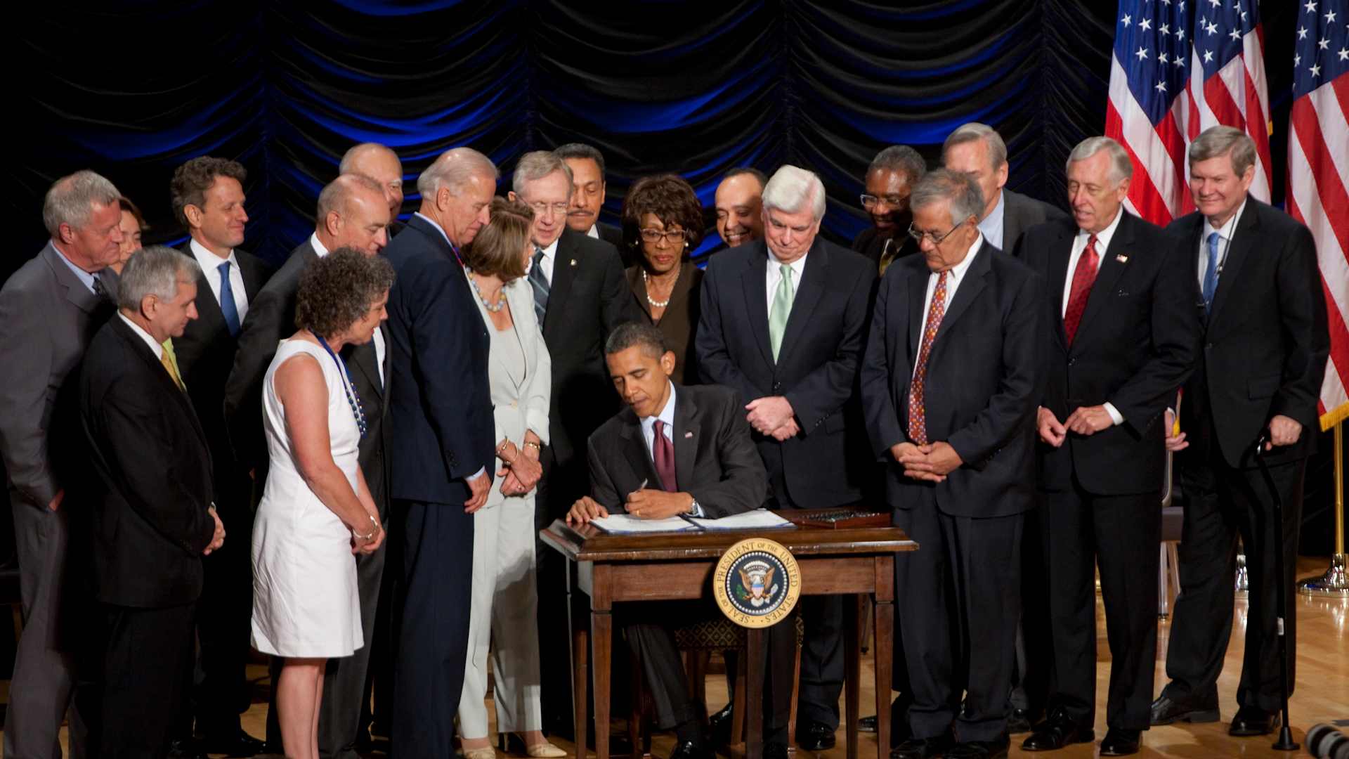 President Barack Obama signs the Dodd-Frank Wall Street Reform and Consumer Protection financial overhaul bill at the Ronald Reagan Building in Washington. Pictured from left to right: Rep. Collin Peterson, D-Minn., Sen. Jack Reed, D-R.I., Sen. Blanche Lincoln, D-Ark., Treasury Secretary Timothy Geithner, teacher Robin Fox, Vietnam veteran Andrew Giordano, Rep. Paul Kanjorski, D-Pa., Vice President Joe Biden, House Speaker Nancy Pelosi, D-Calif., Senate Majority Leader Harry Reid, D-Nev., Rep. M (Photo by Brooks Kraft LLC/Corbis via Getty Images)