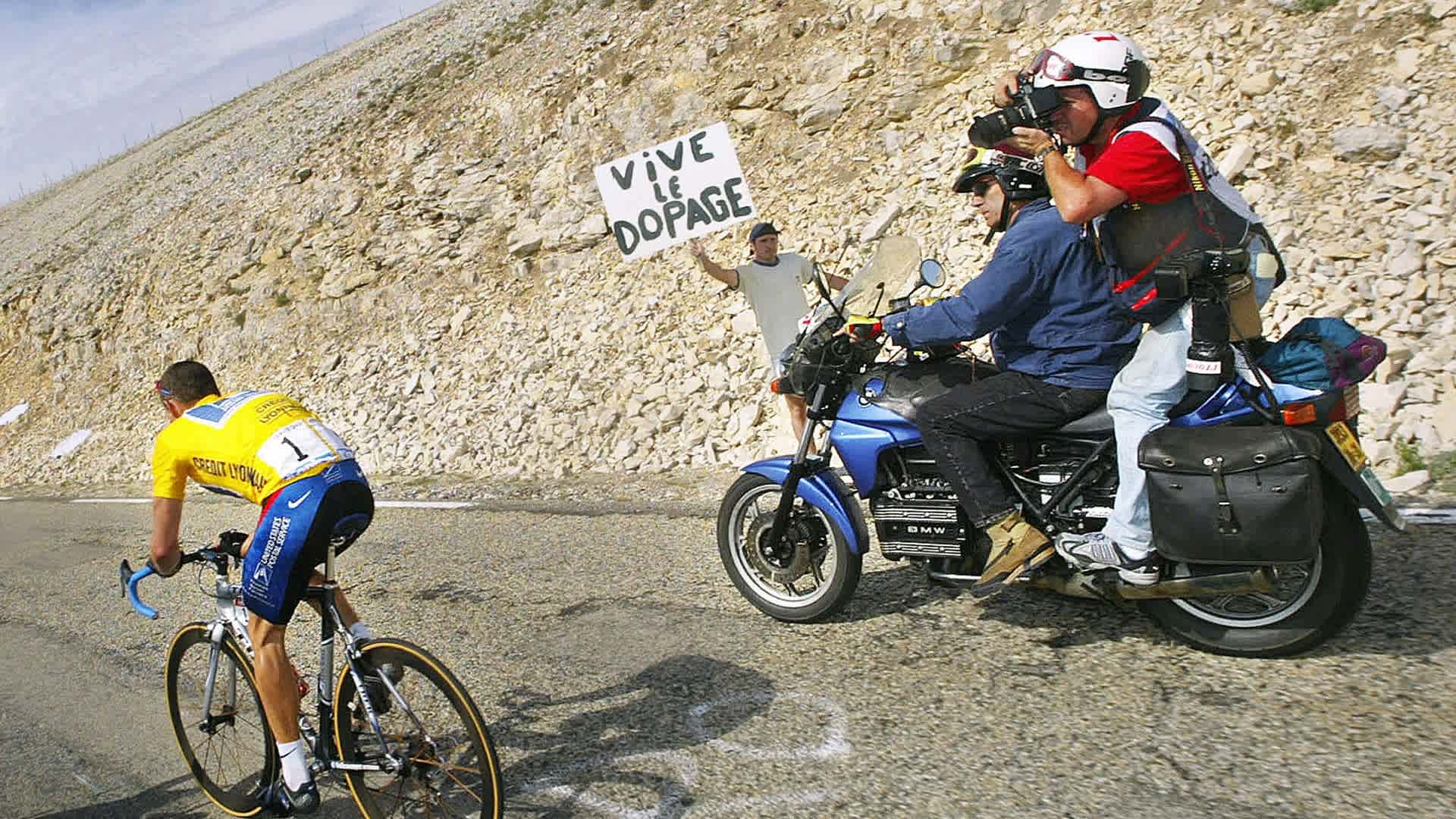 Lance Armstrong climbing the Mont Ventoux next to a banner against doping during the 14th stage of the 89th Tour de France between Lodeve and the Mont Ventoux, 21 July 2002
