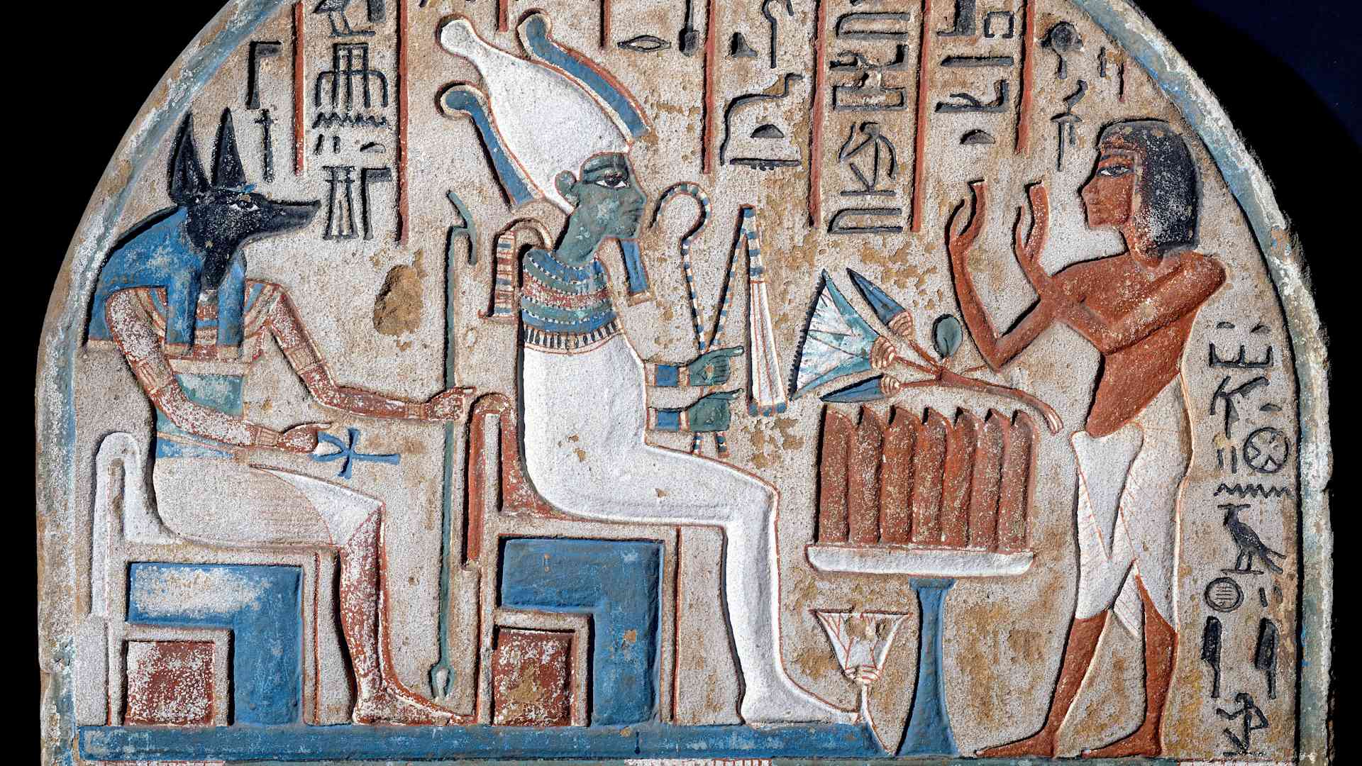 Nanai stele depicting Nanai worshiping the Gods Osiris and Anubis, the dead deity who holds the key of life, ankh-shaped (Ankh). Limestone painted. End of the 18th dynasty. 14th century BC. Egyptian Museum, Turin, Italy (Photo by Leemage/Corbis via Getty Images)