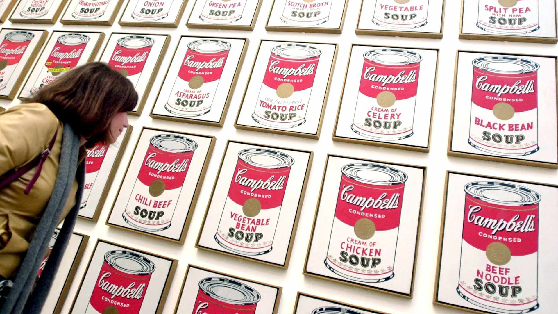 A visitor looks at enigmatic American artist Andy Warhol's "Campbell's Soup Cans" at the Tate Modern in London 05 February 2002. A major retrospective of the controversial Warhol's work is expected to be a highlight of the English capital's cultural year. AFP PHOTO/Nicolas ASFOURI / AFP / NICOLAS ASFOURI (Photo credit should read NICOLAS ASFOURI/AFP via Getty Images)