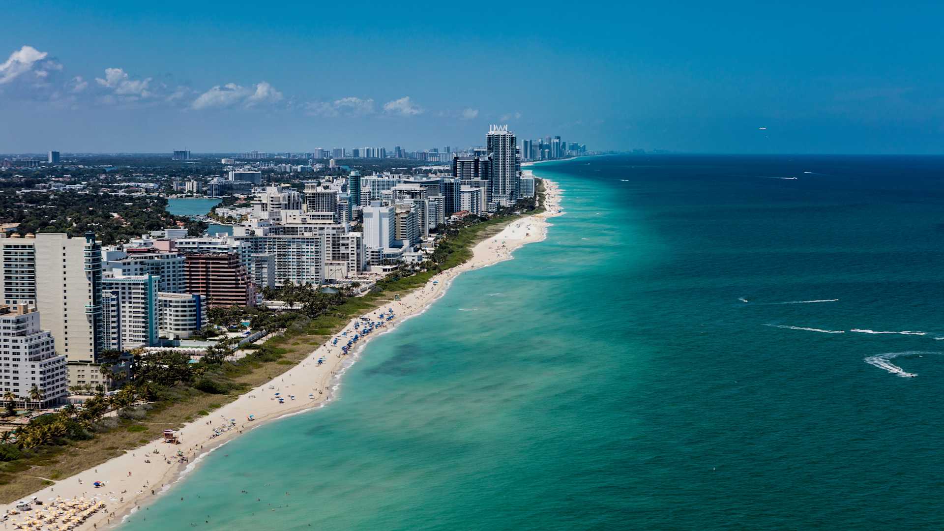 Aerial view of South Beach Miami Florida cityscape with buildings along the beach on a beautiful sunny day, people on beach and ocean.