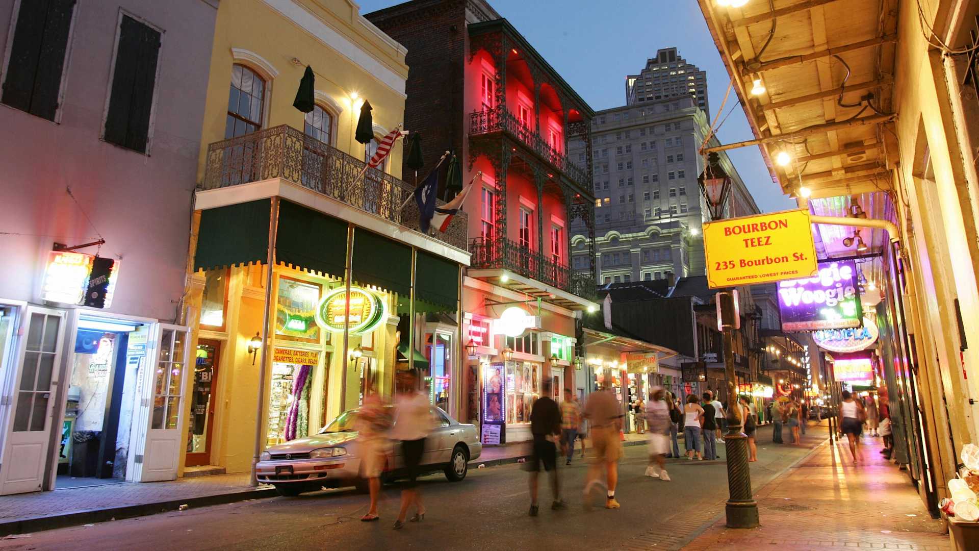 New Orleans, UNITED STATES: Dusk falls over Bourbon Street in the French Quarter of New Orleans, 11 July 2006, almost one year after Hurricane Katrina devastated the city. For tourists strolling through the French Quarter it's easy to forget that Hurricane Katrina ravaged New Orleans a year ago. The beignets are fresh, trinkets and designer clothes are artfully arranged in shop windows, and hurricanes are spinning in the bars on Bourbon Street. But while the music, food and good times have come back, the crowds have not and the city is struggling to make ends meet while its main industry remains crippled. With more than 10 million visitors a year, tourism was once a 5.5 billion dollar industry in New Orleans, accounting for 40 percent of the city's tax revenues and employing 85,000 people. AFP PHOTO / Robyn BECK (Photo credit should read ROBYN BECK/AFP via Getty Images)