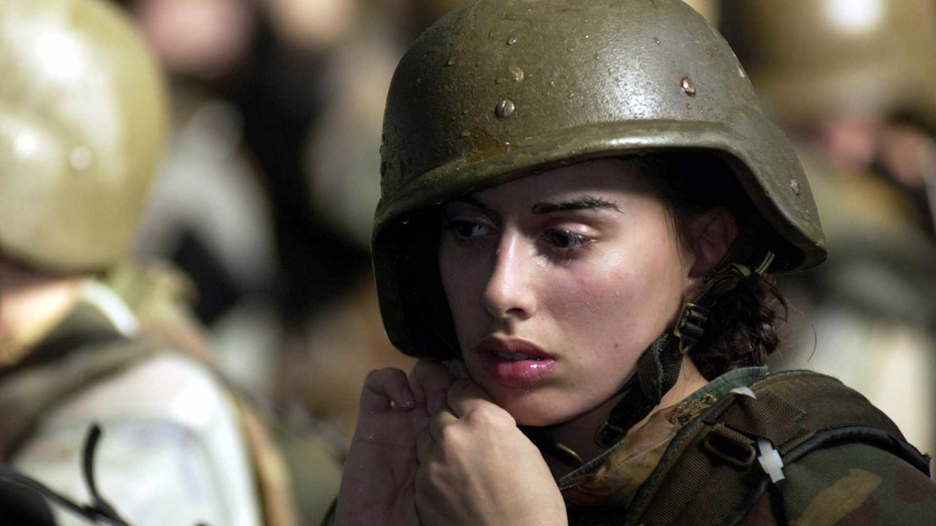 PARRIS ISLAND, SC - JANUARY 15: United States Marine Corps female recruit Stephanie Palladino adjusts her Kevlar helmet January 15, 2003 before re-entering the Combat Pool for another swim lesson during boot camp on Parris Island, SC. Under the watchful eyes of swim instructors, recruits are required to swim in full gear and learn limited strokes and breathing to stay afloat along with life saving techniques. (Photo by Stephen Morton/Getty Images)