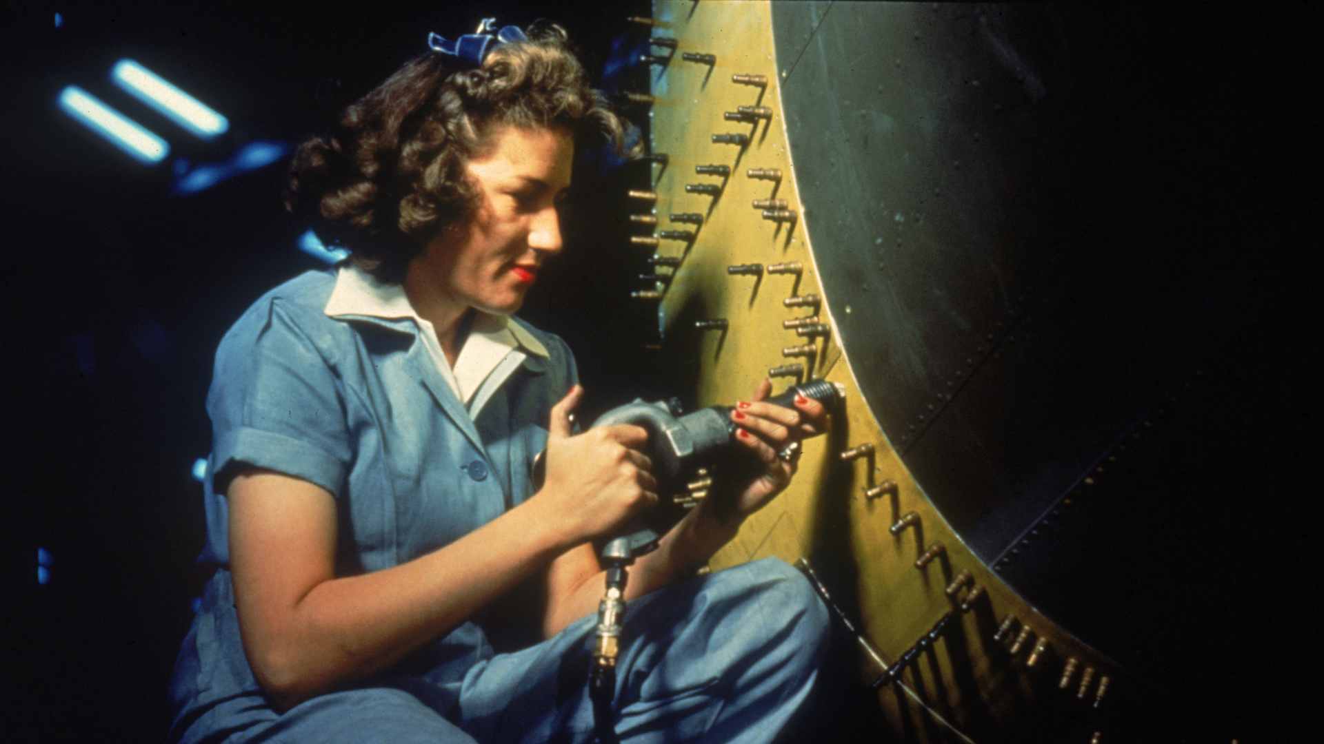 Portrait of an unidentified female riveter at work during WWII on bomber at Consolidated Aircraft Corporation, Fort Worth, Texas, October 1942.