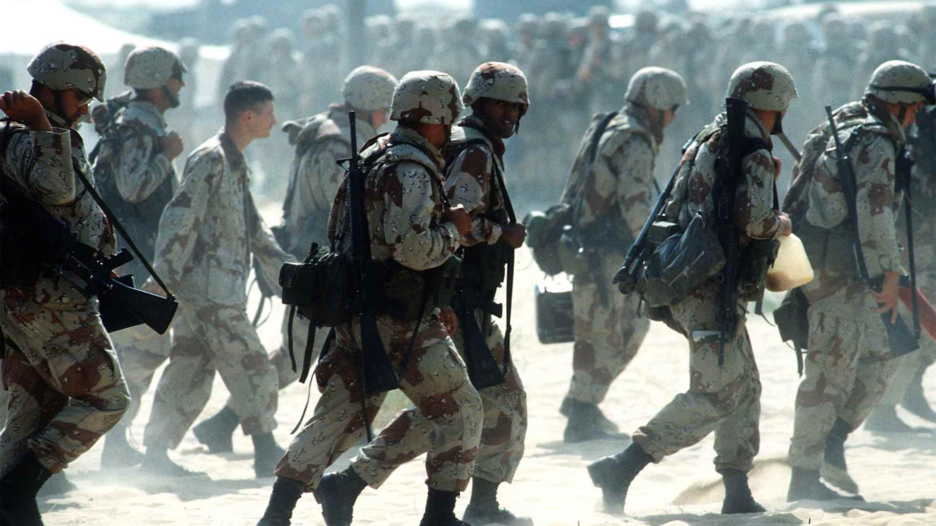 Newly arrived Marines are led through an encampment near an airfield during the Persian Gulf War's Operation Desert Shield.