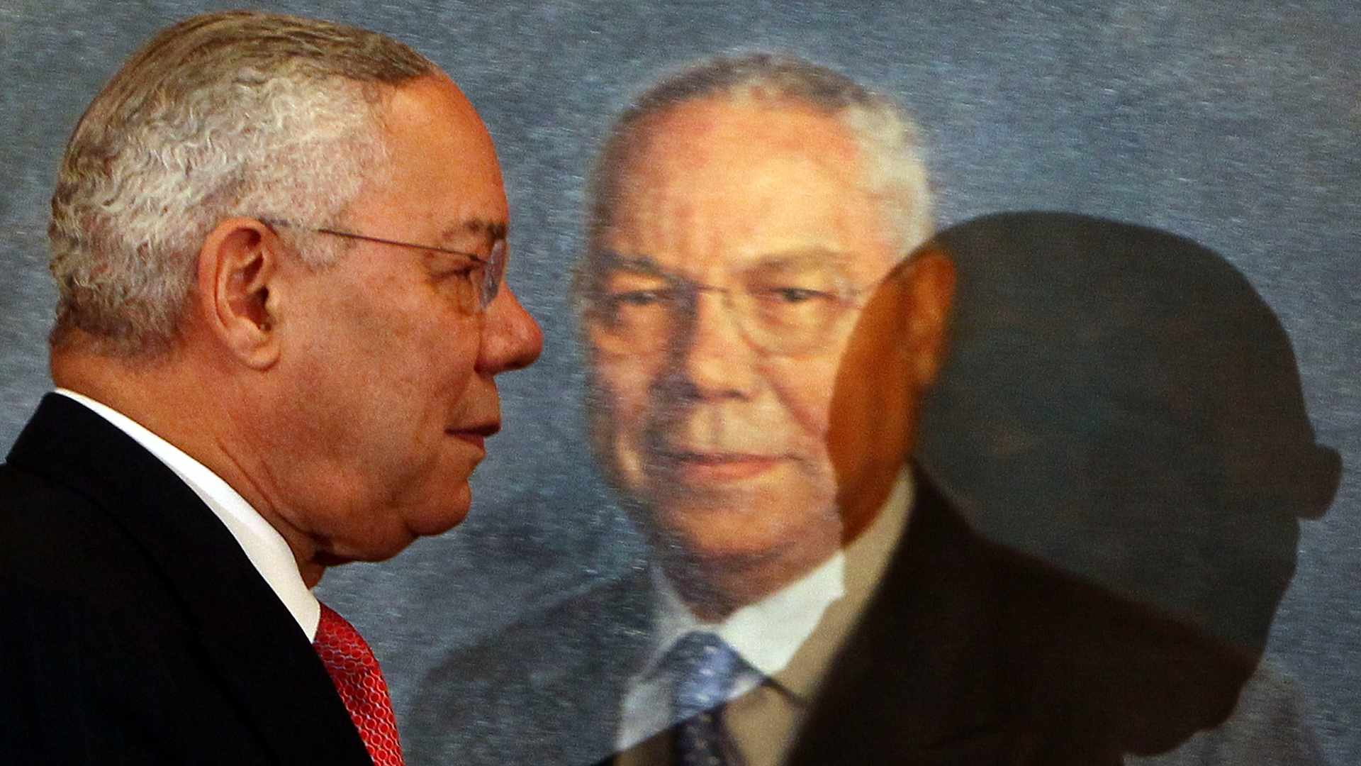 Former U.S. Secretary of State Colin Powell walks by his official State Department portrait after an unveiling ceremony.
