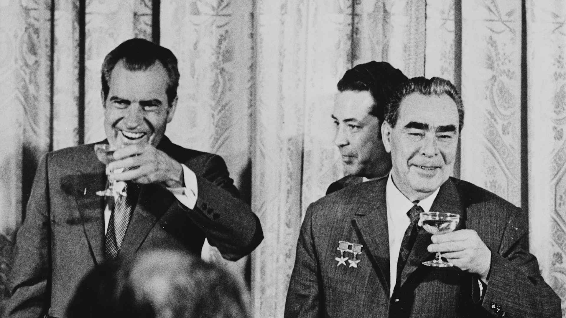 US President Richard Nixon (1913 - 1994, left) and Russian leader Leonid Brezhnev (1906 - 1982, right) share a champagne toast.