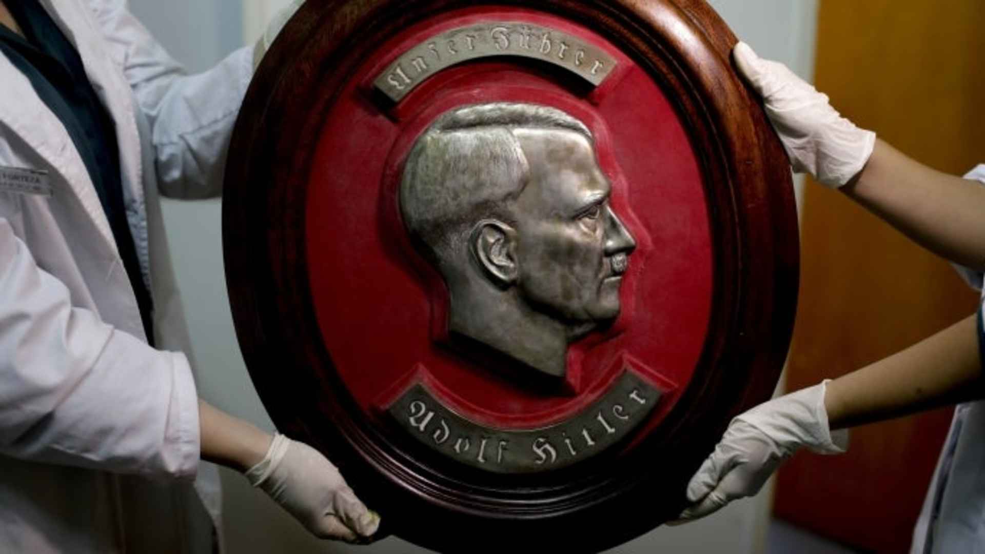 Members of the federal police show a bust relief portrait of Nazi leader Adolf Hitler at the Interpol headquarters in Buenos Aires, Argentina, Friday, June 16, 2017. In a hidden room in a house near Argentina's capital, police discovered on June 8th the biggest collection of Nazi artifacts in the country's history. Authorities say they suspect they are originals that belonged to high-ranking Nazis in Germany during World War II.