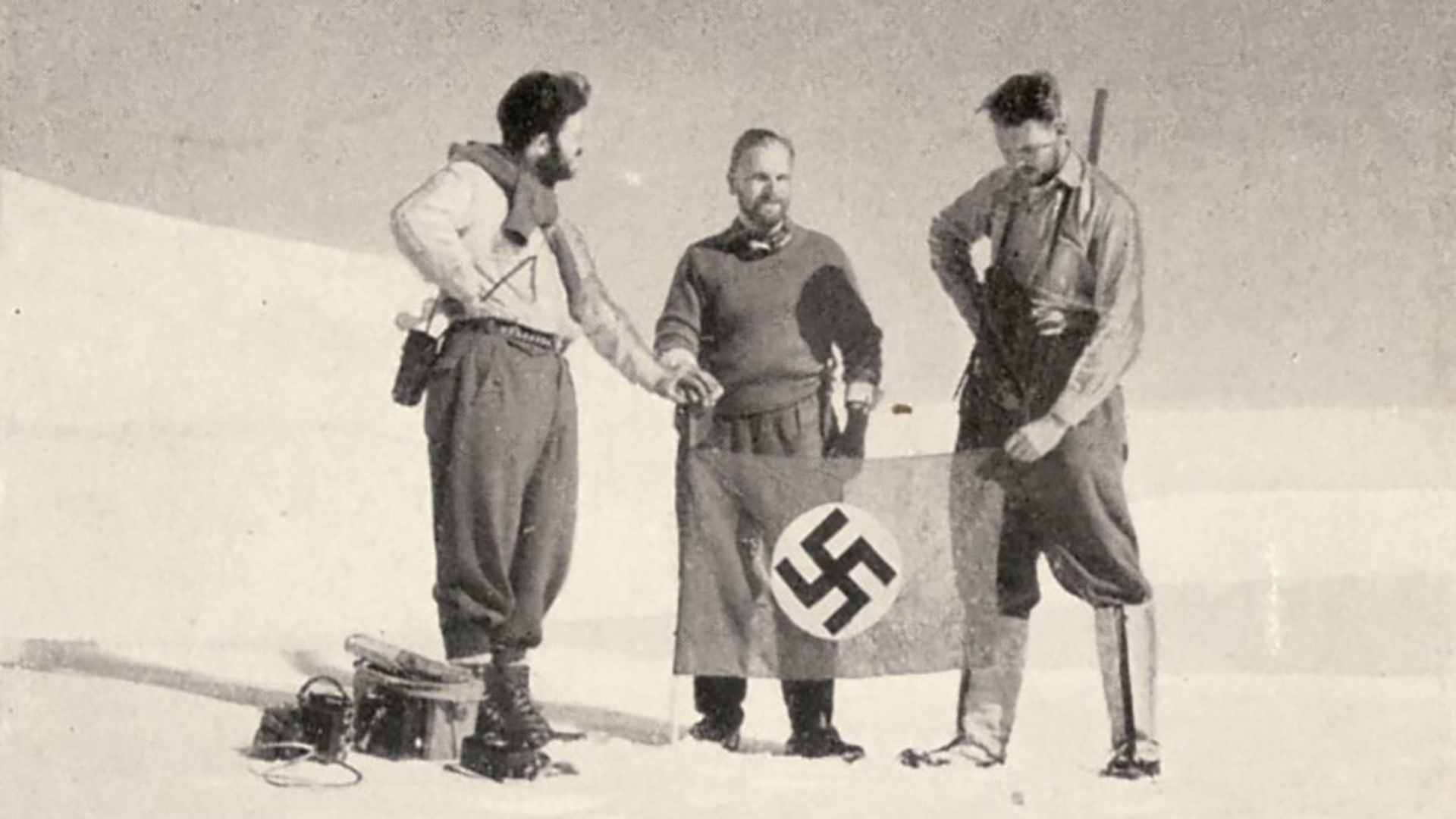 German men showing off a Nazi flag while on expedition from the book, "The Third Reich in Antarctica: The German Antarctic Expedition 1938-39."
